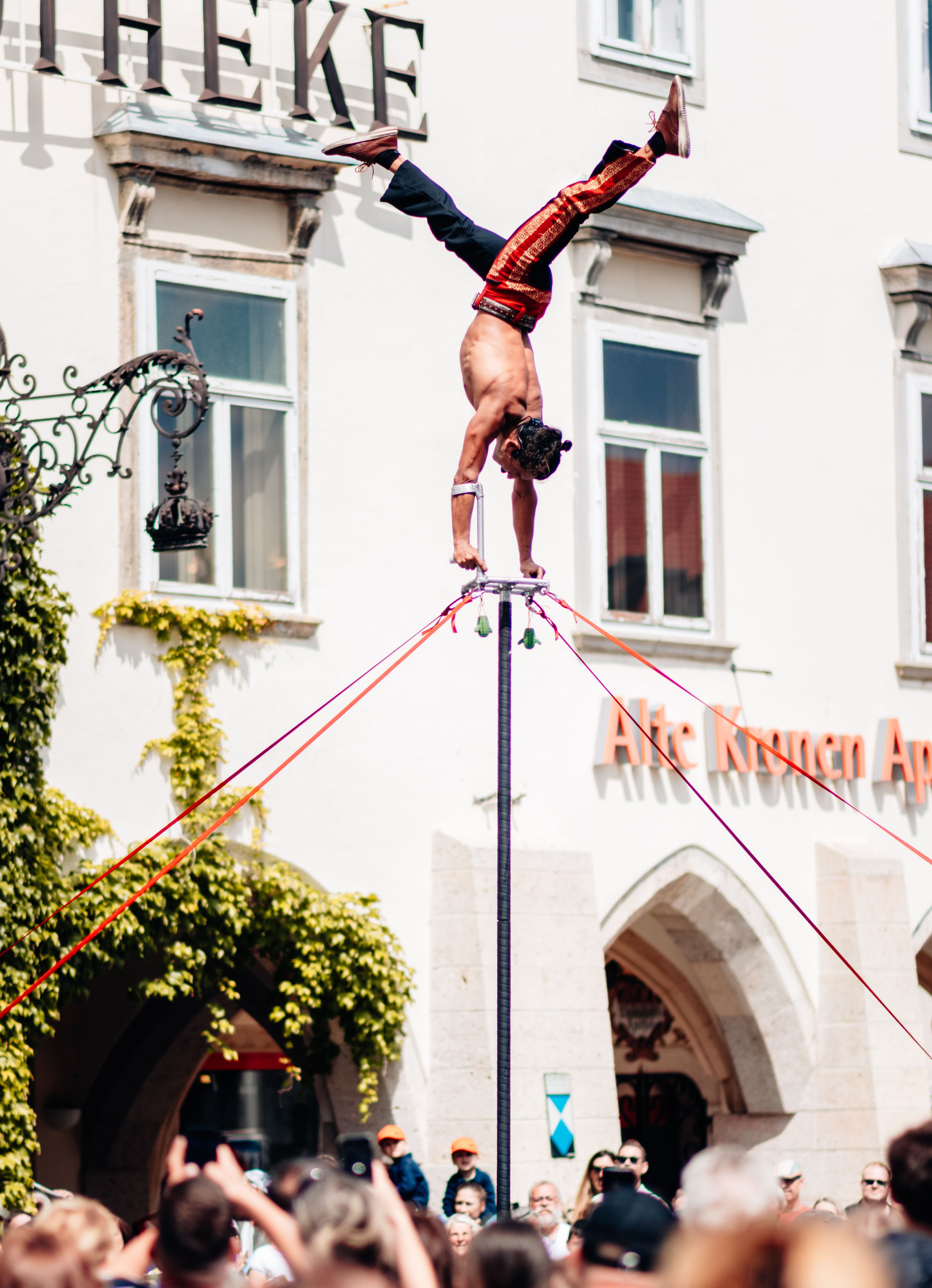 Akrobat tanzt auf einem Stab in der Innenstadt von Wiener Neustadt. 