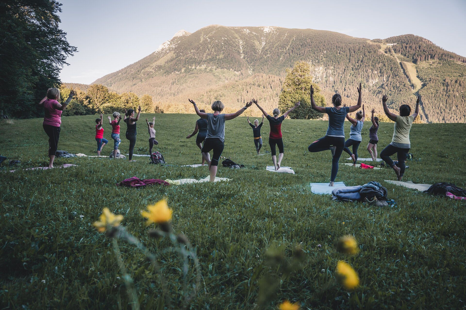 Inmitten der malerischen Berglandschaft praktizieren die Teilnehmer Yoga und finden innere Ruhe. Die sanften Bewegungen und die frische Luft schaffen eine harmonische Verbindung zur Natur. Umgeben von blühenden Wiesen und majestätischen Gipfeln wird jede Pose zu einem Erlebnis der Achtsamkeit.