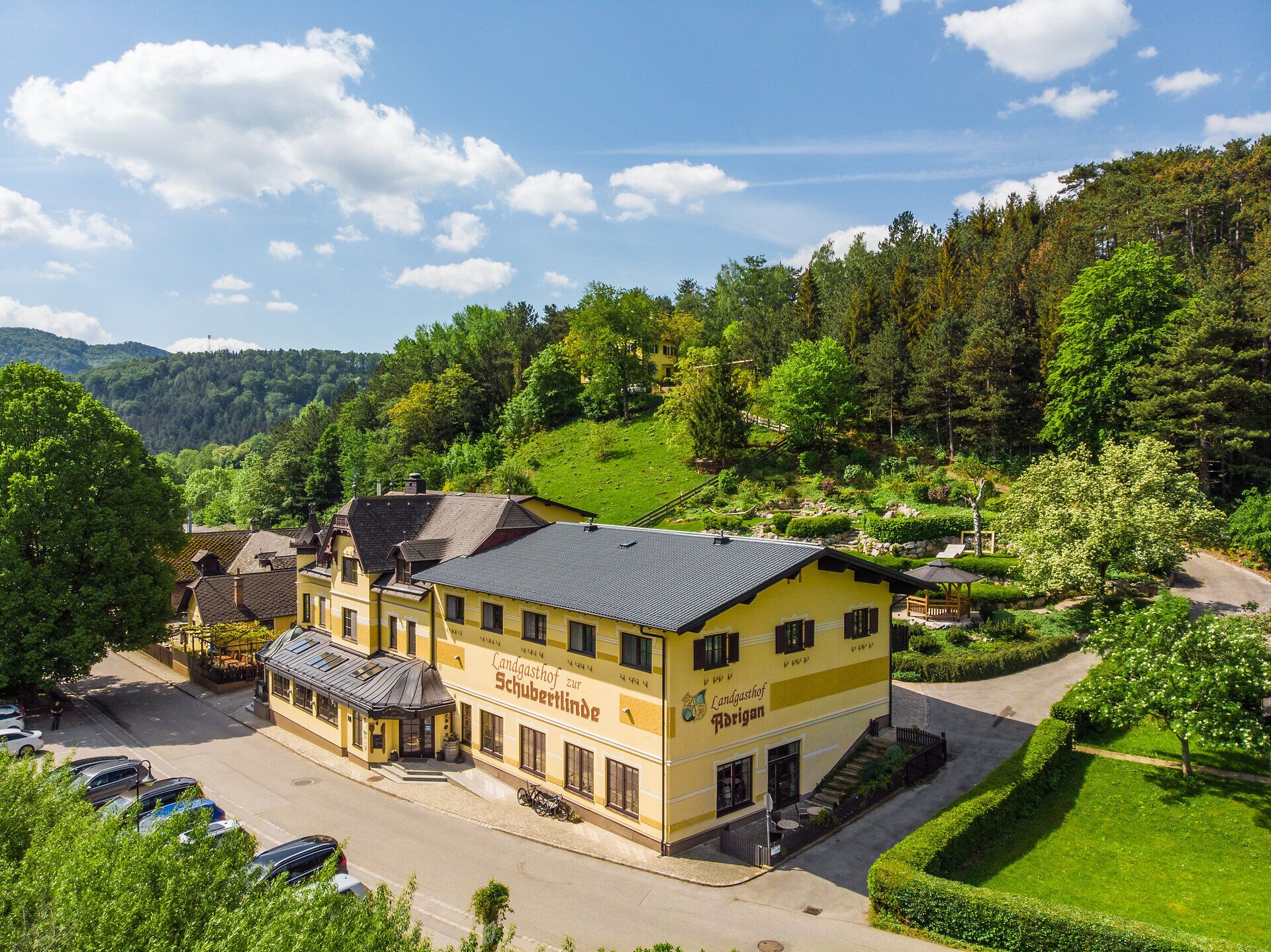 Außenaufnahme vom Landgasthof „Zur Schubertlinde“ mit Einsicht in den Garten hinter dem Gasthof.