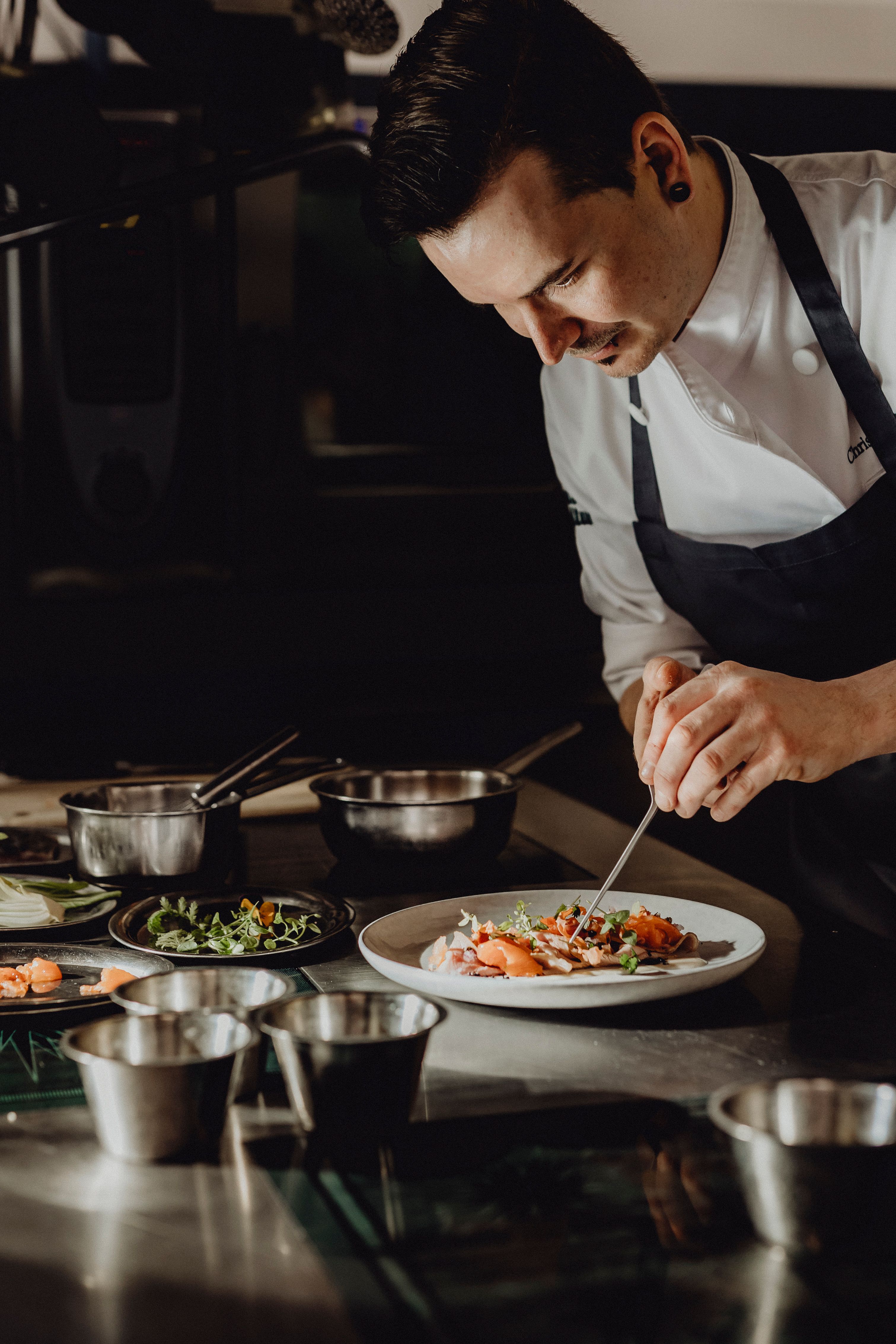 Suppe wird aus einem kleinen Krug in einen Teller gegossen.