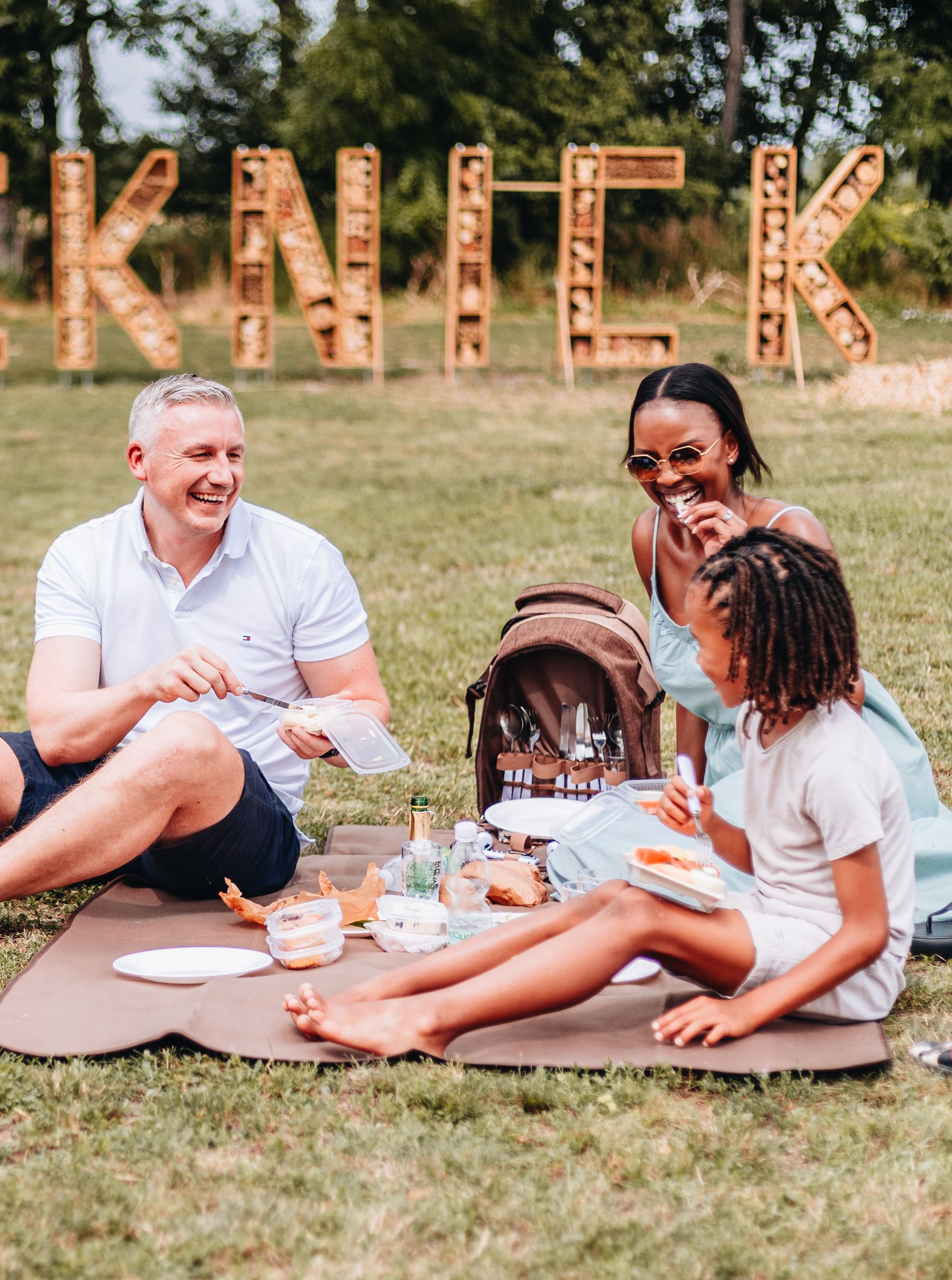 Menschen picknicken auf einer Wiese. 