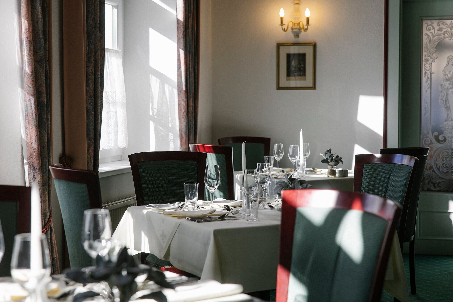 Eleganter Speiseraum mit gedeckten Tischen und klassischer Einrichtung.