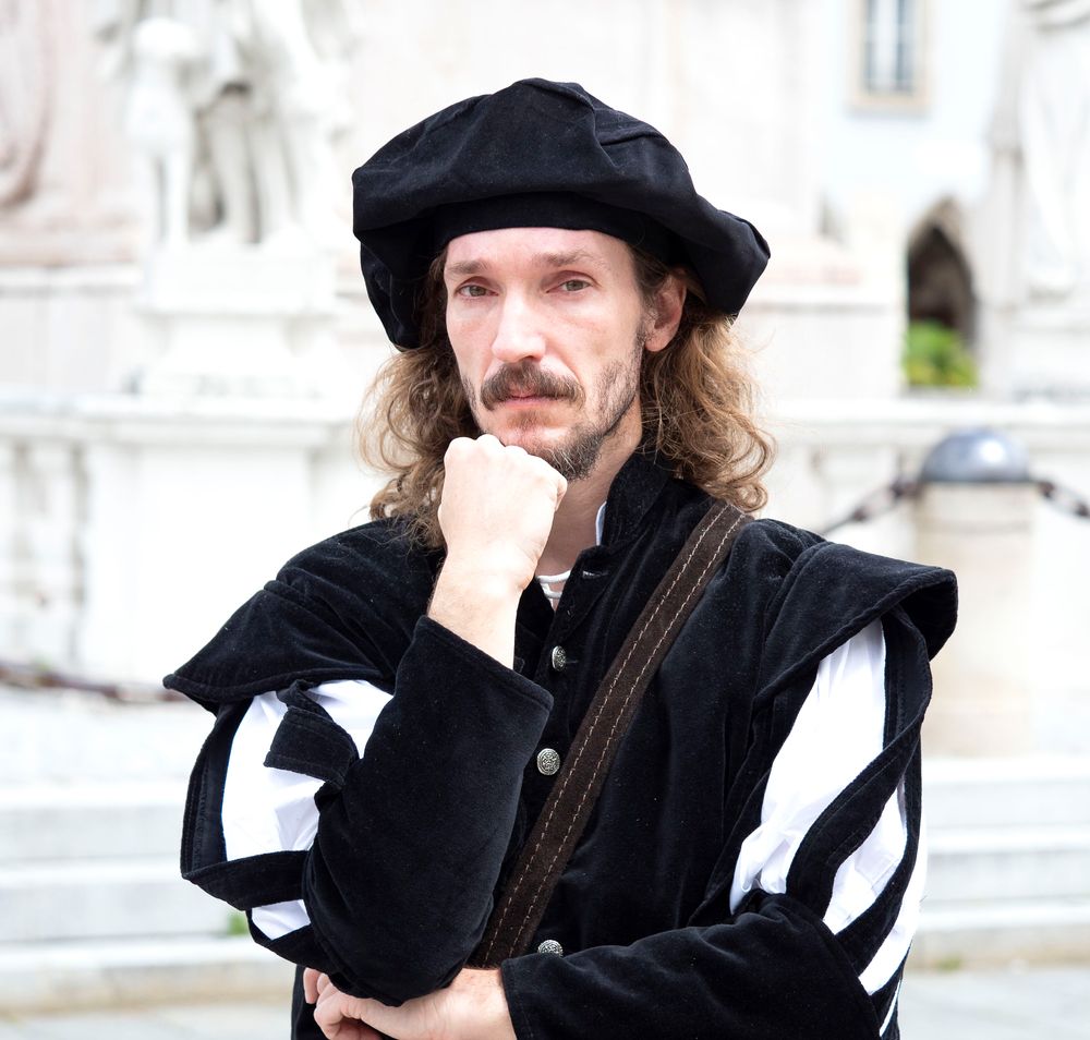 Verkleideter Mann vor einem Denkmal. 