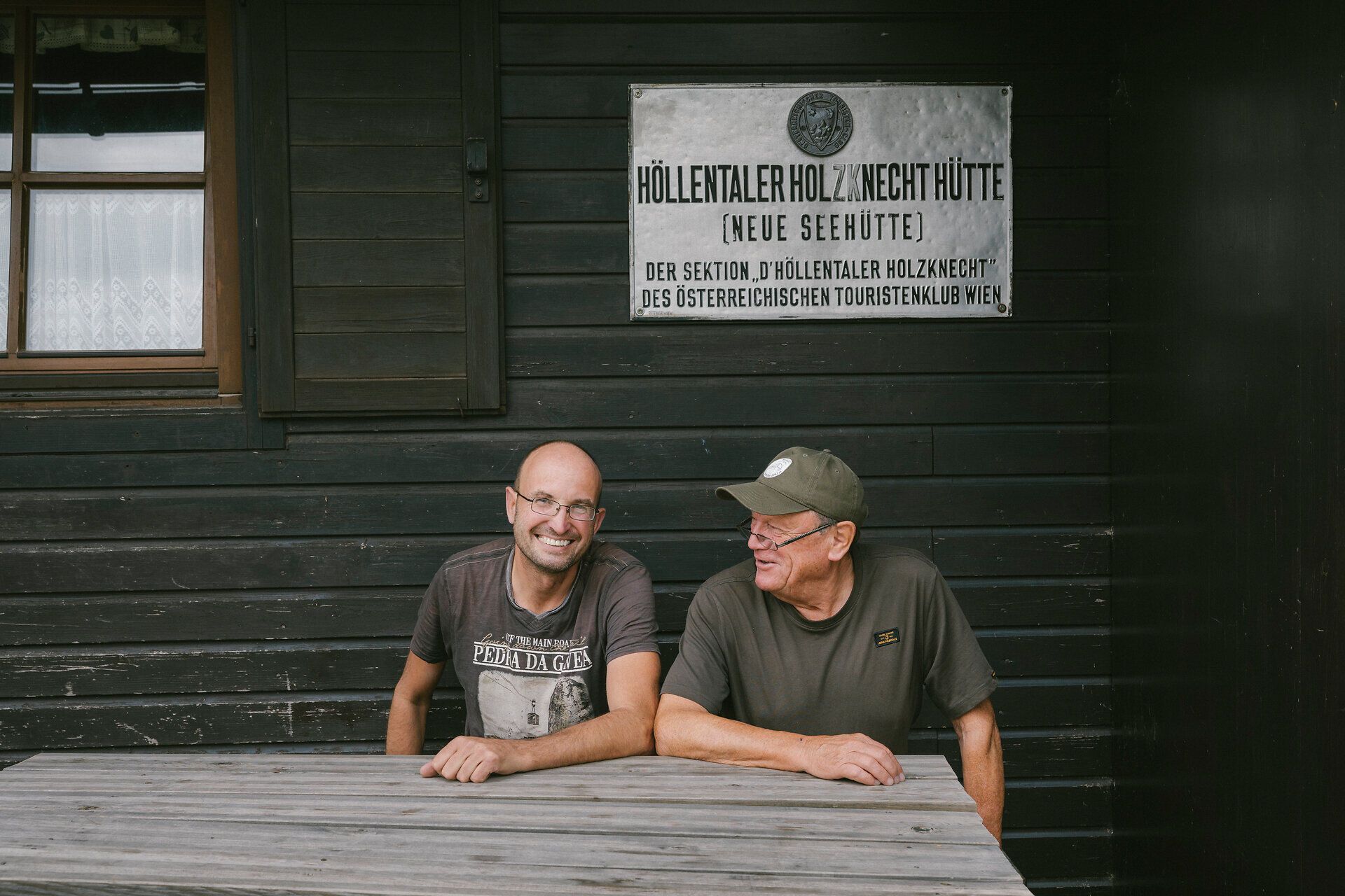 Zwei Hüttenwirte der Neuen Seehütte auf der Rax sitzen gemeinsam vor der Hütte