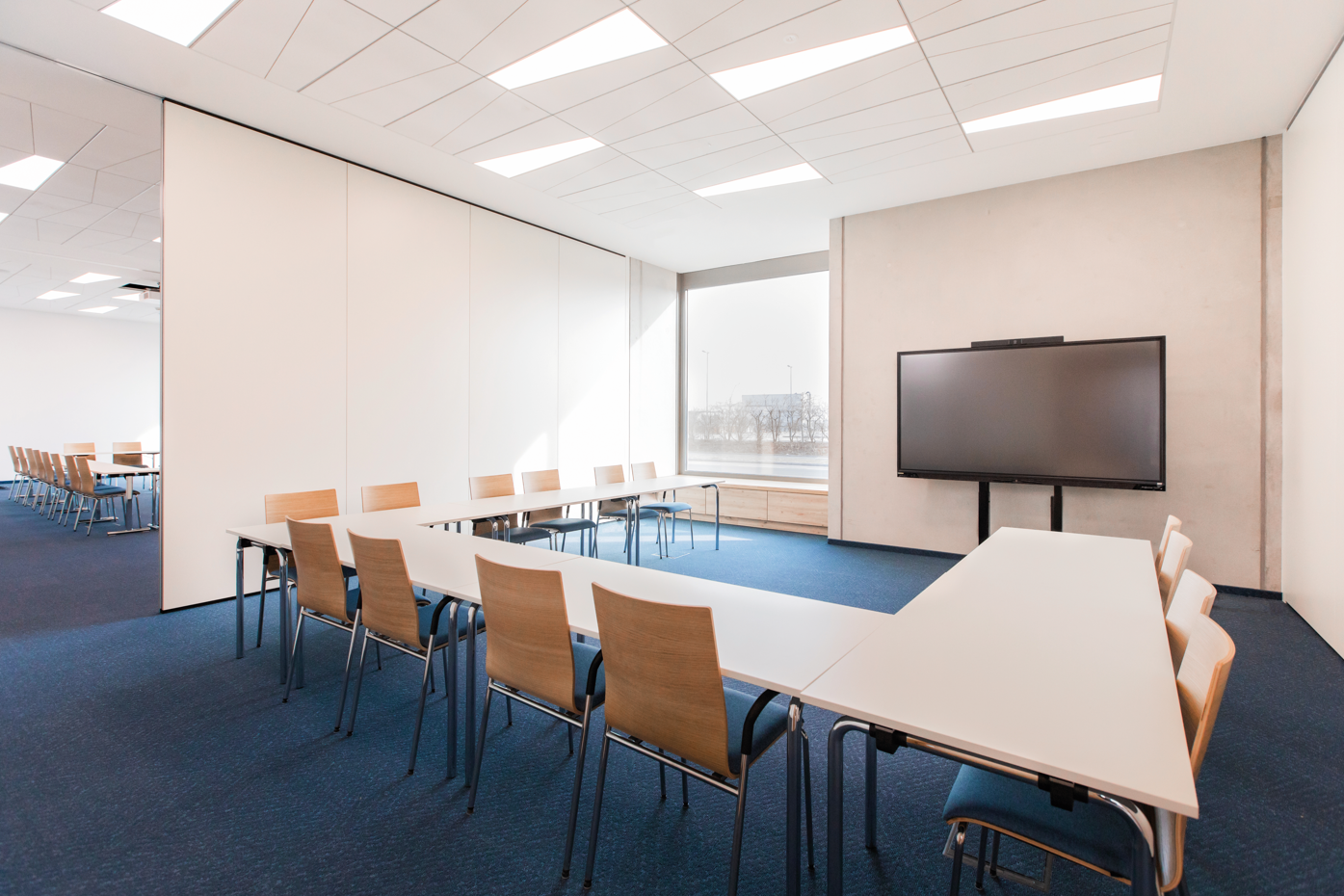 Seminarraum mit Trennwänden, U-Bestuhlung und Fernseher.