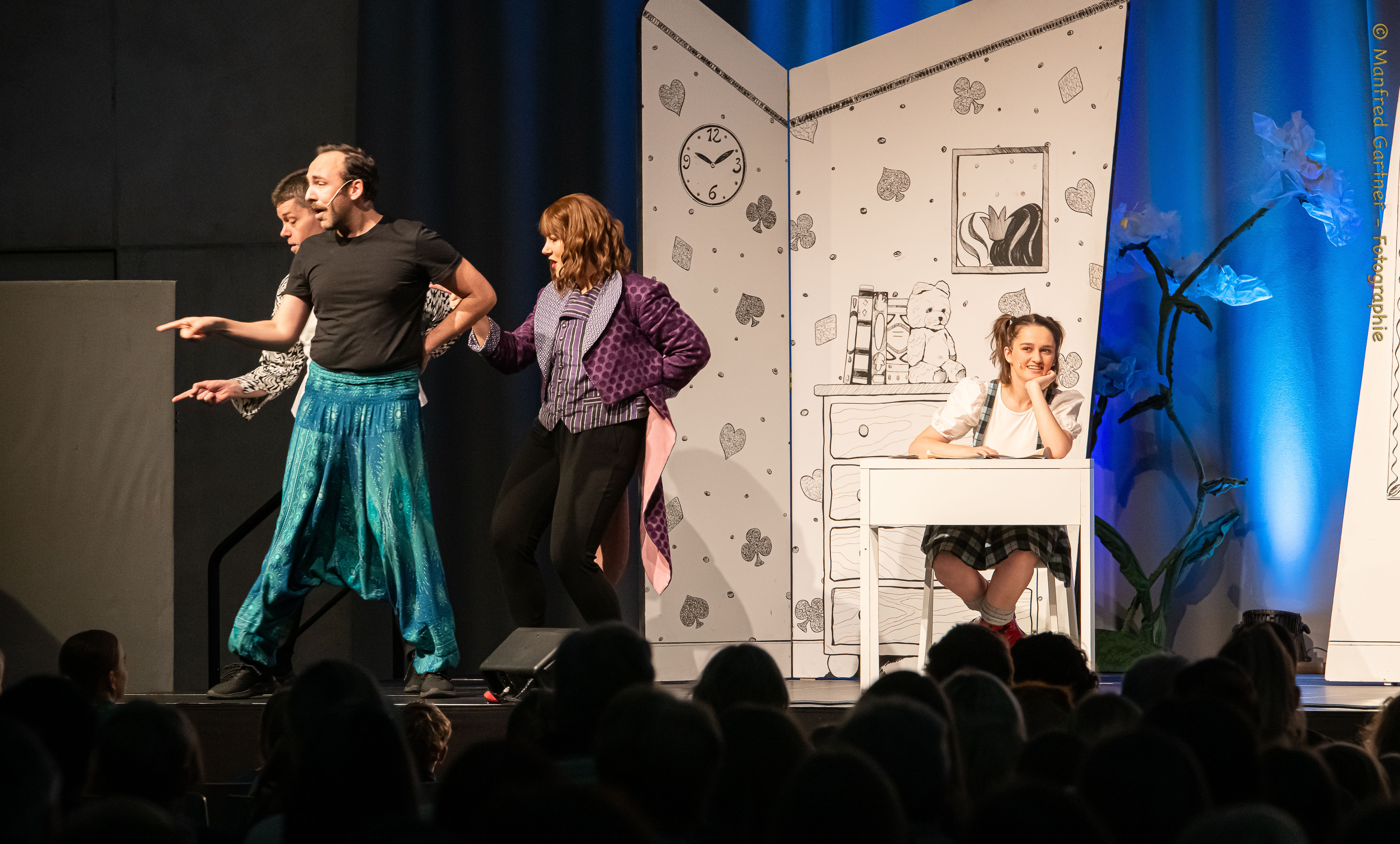 Menschen treten auf einer Bühne auf. 