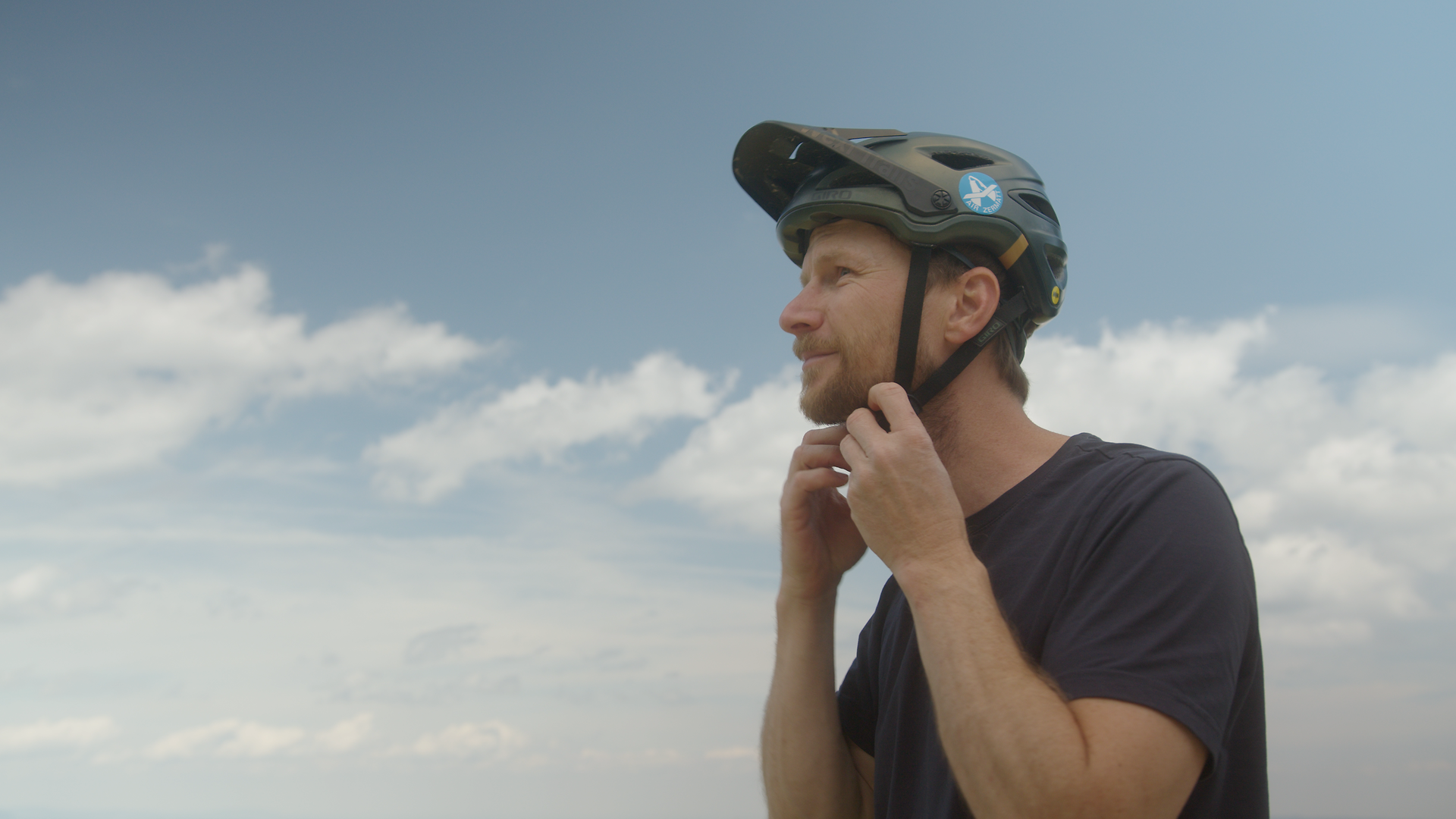 Ein begeisterter Mountainbiker genießt die frische Bergluft und die atemberaubende Aussicht auf die umliegenden Gipfel. Mit seinem Helm bereit für das Abenteuer, strahlt er Vorfreude auf die bevorstehenden Trails aus, die durch die malerische Landschaft der Wiener Alpen führen.