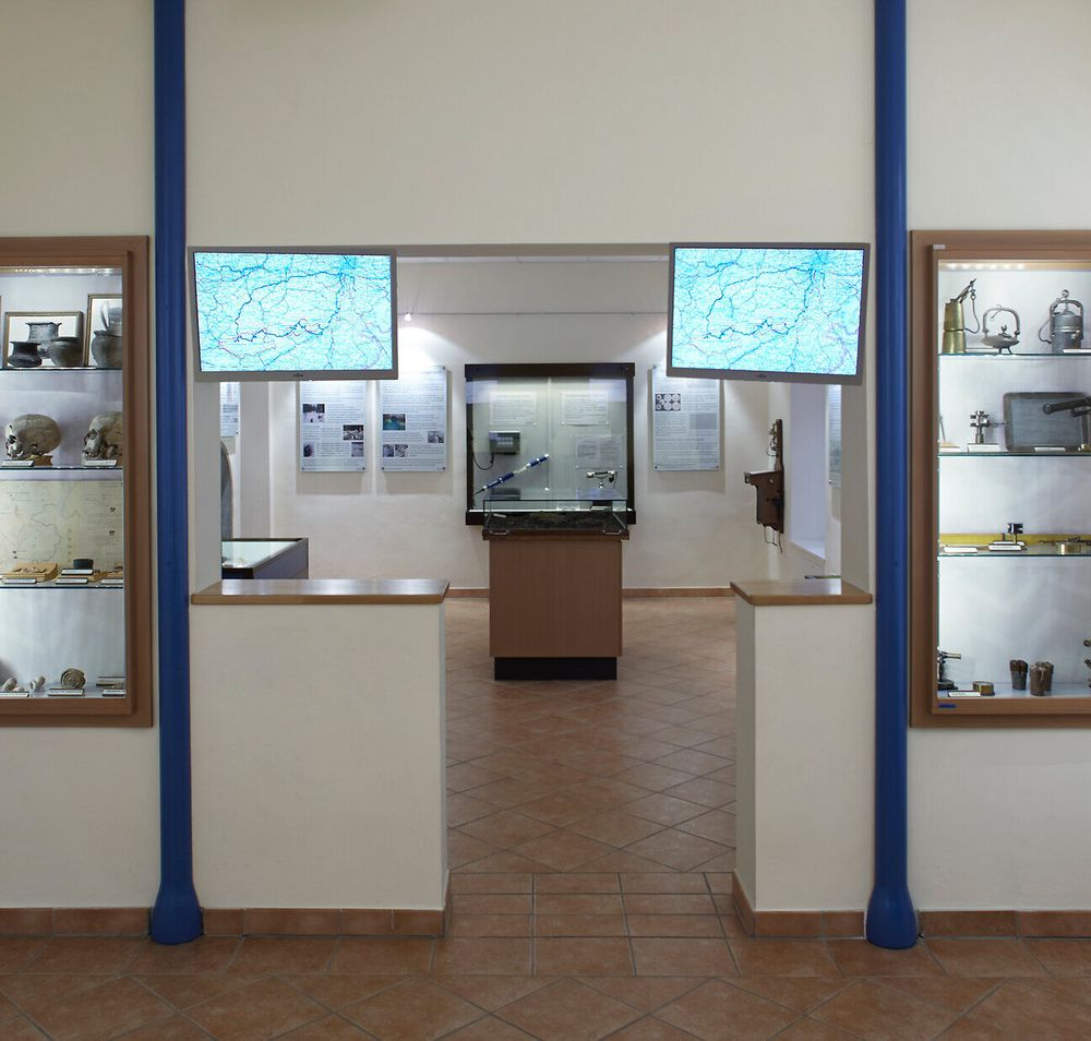 Museumsraum mit Vitrinen und ausgestellten Objekten.