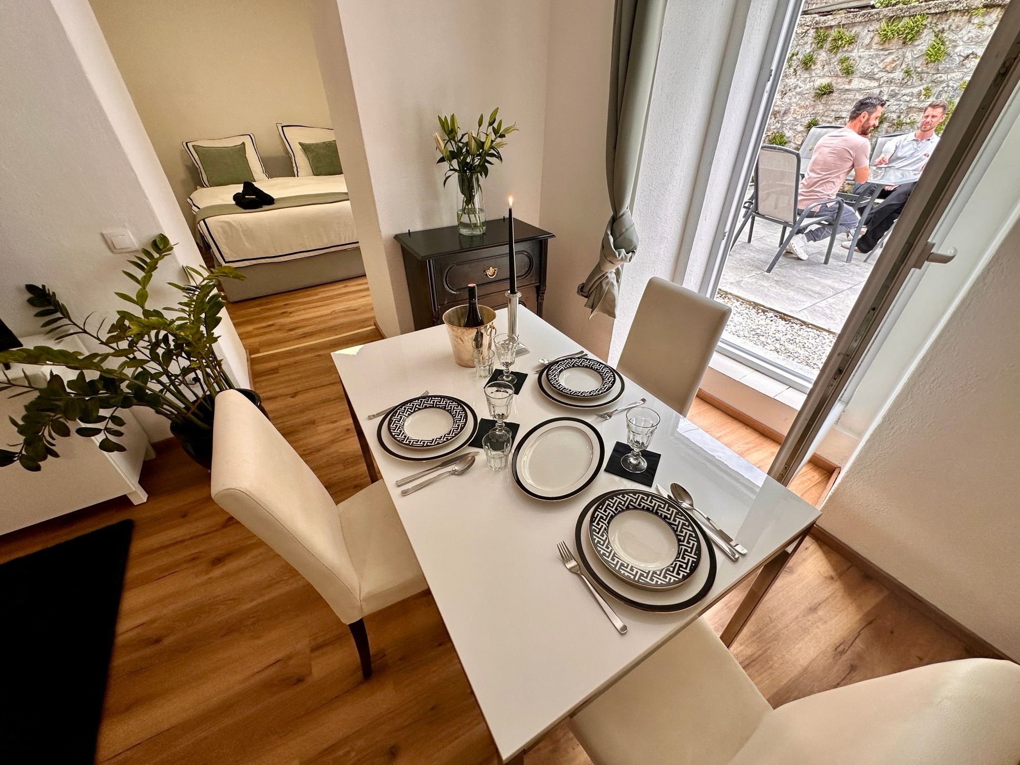 Innenansicht eines modernen Apartments mit Essbereich, Schlafzimmer und Terrasse.