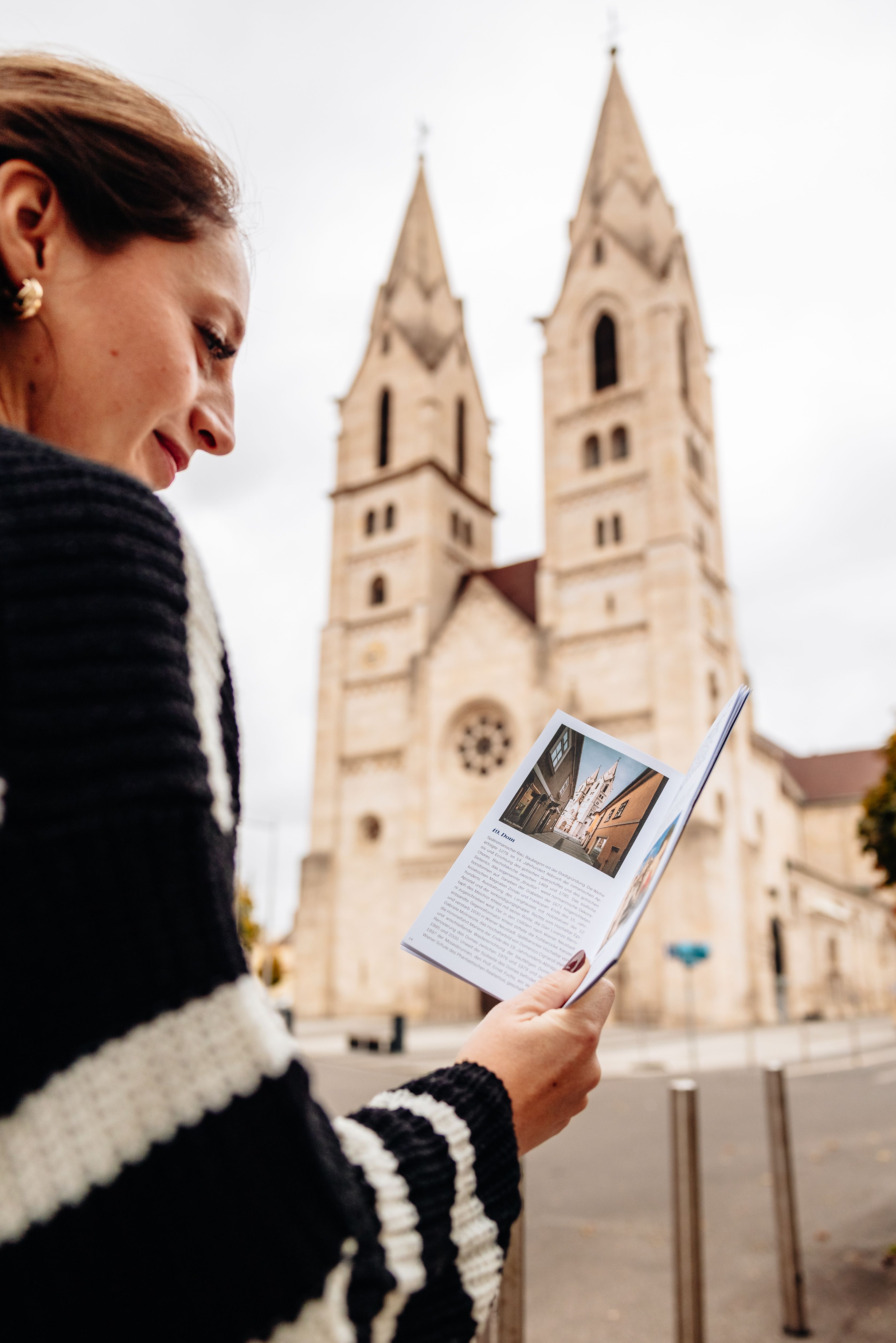 Frau mit Flyer vor dem Wiener Neustädter Dom. 