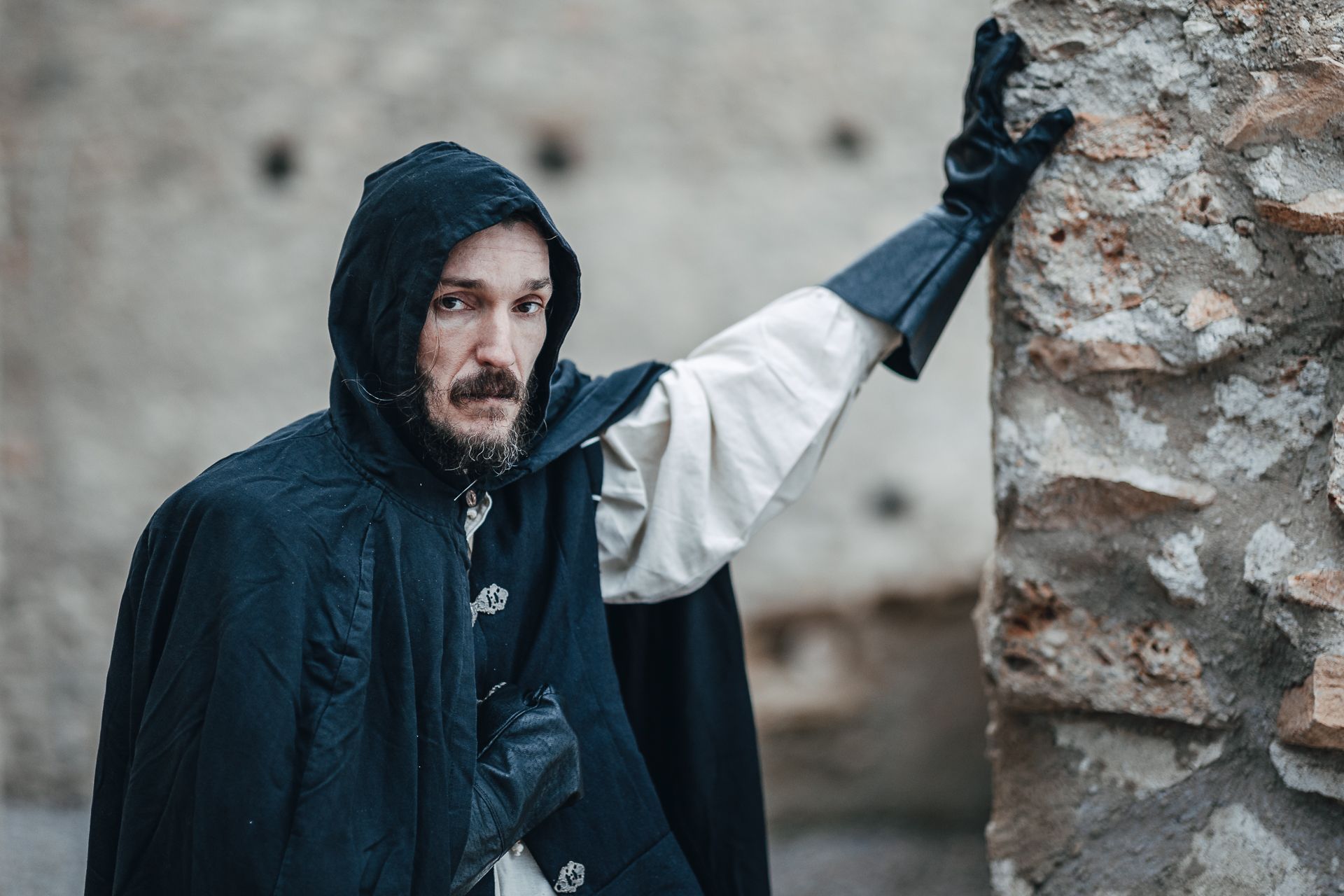 verkleideter Mann im Henkerskostüm lehnt an einem Baum 