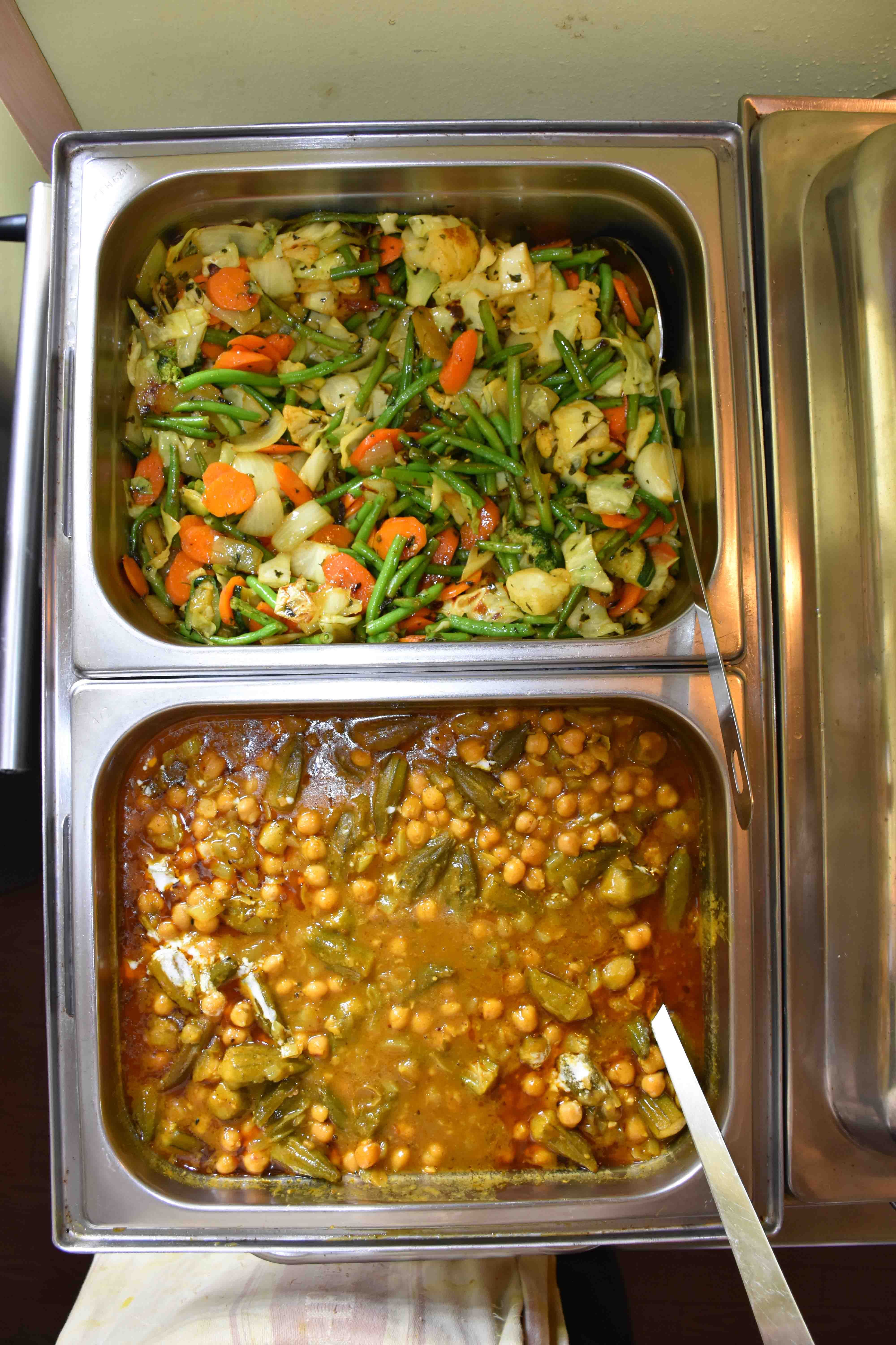 Zwei verschiedene indische Gemüsegerichte in Metallbehältern.