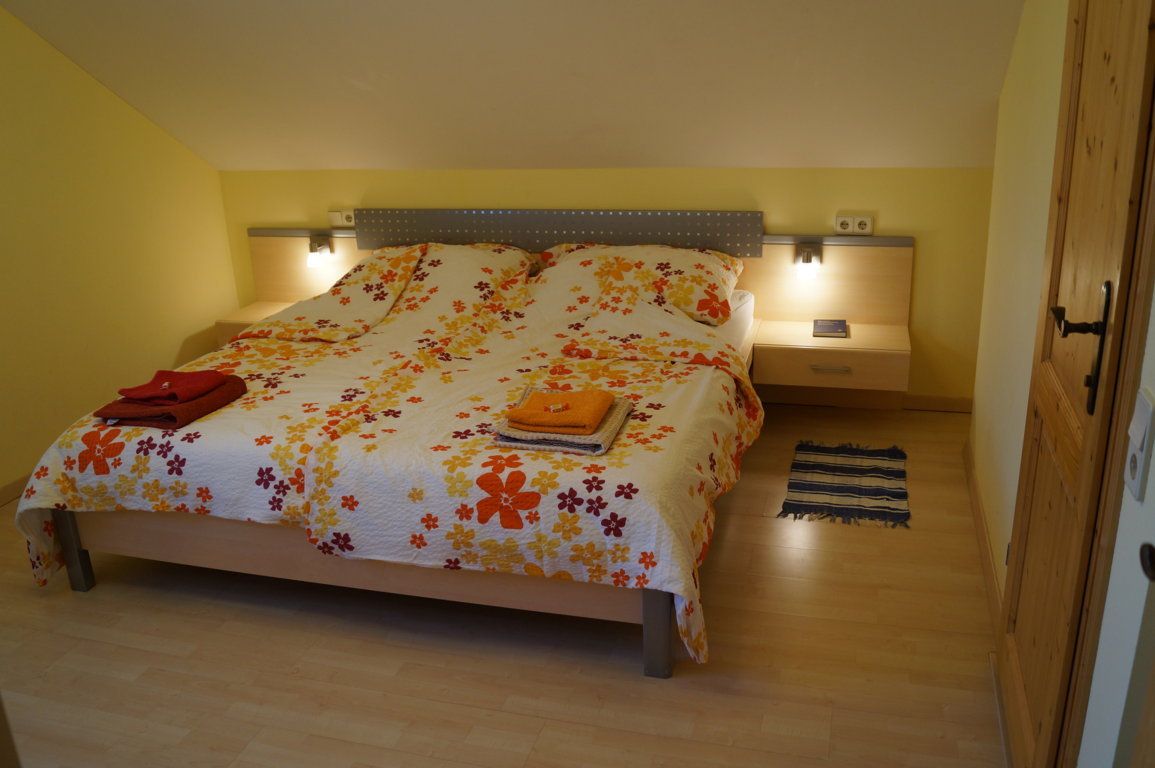 Gemütliches Schlafzimmer mit Doppelbett und Blumenbettwäsche.