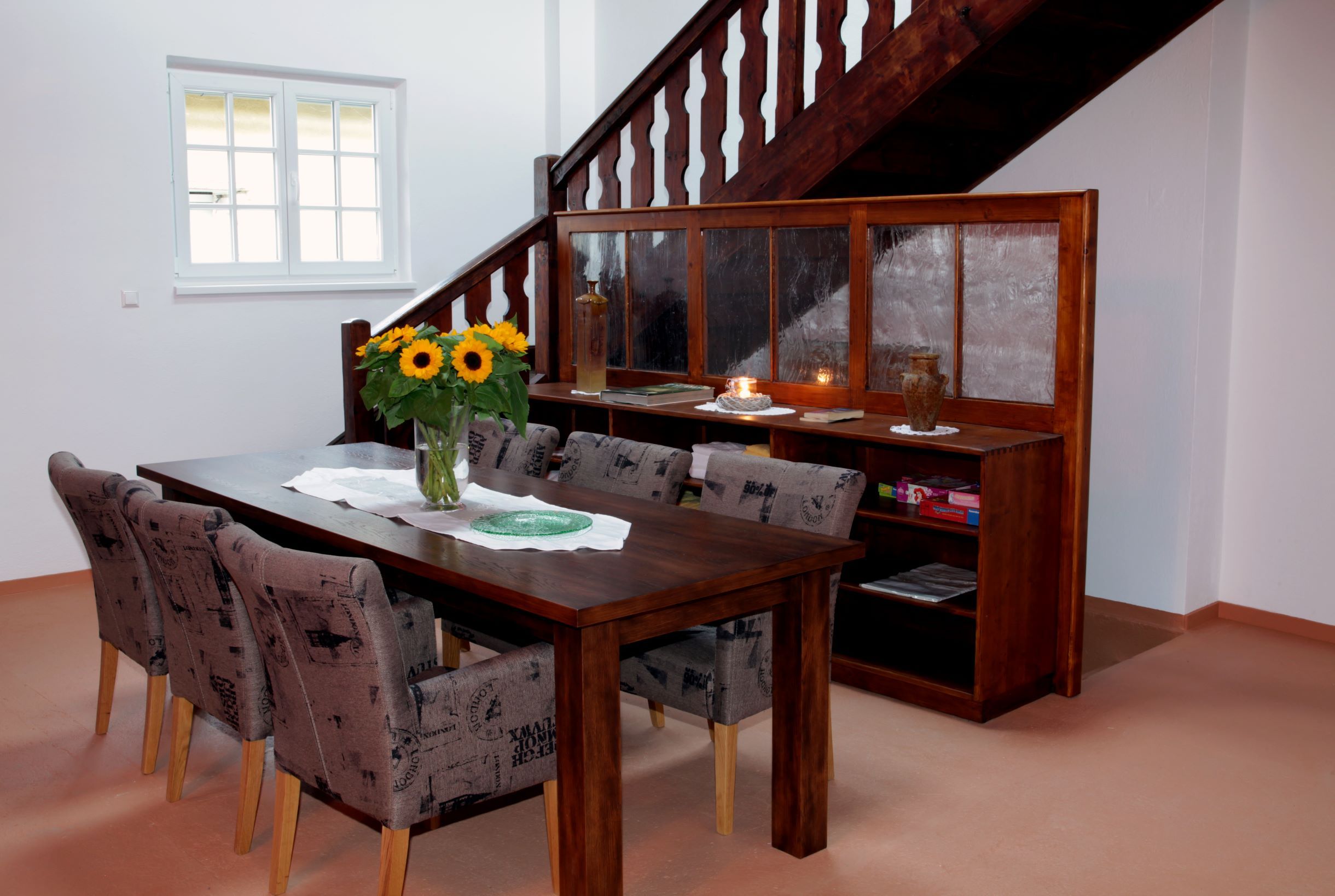 Essbereich mit Holztisch, Stühlen und Sonnenblumen in einem Loft.