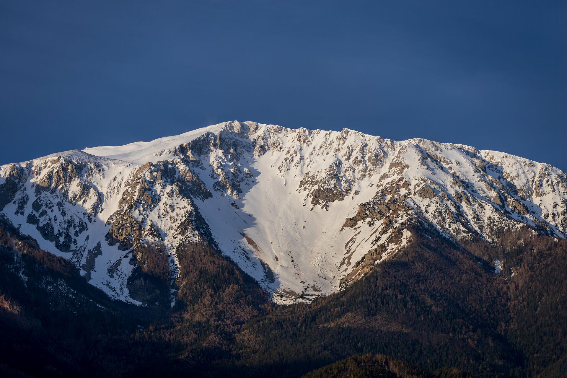 Die majestätischen, schneebedeckten Gipfel erheben sich stolz gegen den klaren blauen Himmel und laden zu unvergesslichen Abenteuern in der Natur ein. Die frische Bergluft und die atemberaubenden Ausblicke schaffen eine Atmosphäre der Ruhe und Erholung, perfekt für Wanderer und Naturliebhaber. Hier, in den Wiener Alpen, wird jeder Schritt zu einem Erlebnis der besonderen Art.