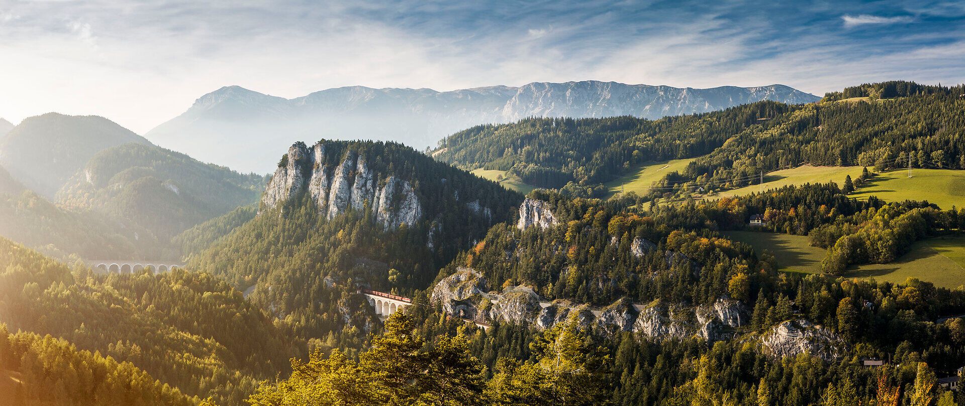 Die majestätischen Berge erheben sich stolz in den Himmel, während die sanften Hügel mit üppigem Grün bedeckt sind. Ein klarer Himmel und die warmen Sonnenstrahlen schaffen eine einladende Atmosphäre, die zum Verweilen und Entdecken einlädt. Hier, wo die Natur in voller Pracht erblüht, wird jeder Schritt zu einem unvergesslichen Erlebnis.