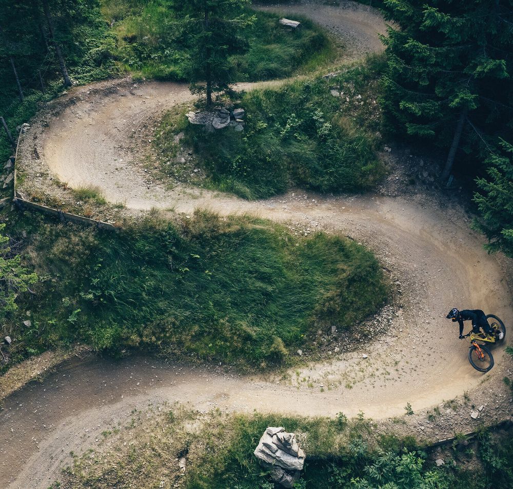 Die kurvenreiche Strecke schlängelt sich durch dichte Wälder, während Mountainbiker mit Begeisterung die Herausforderung annehmen. Die frische Bergluft und das Rascheln der Blätter schaffen eine unvergessliche Atmosphäre für Abenteuerlustige.