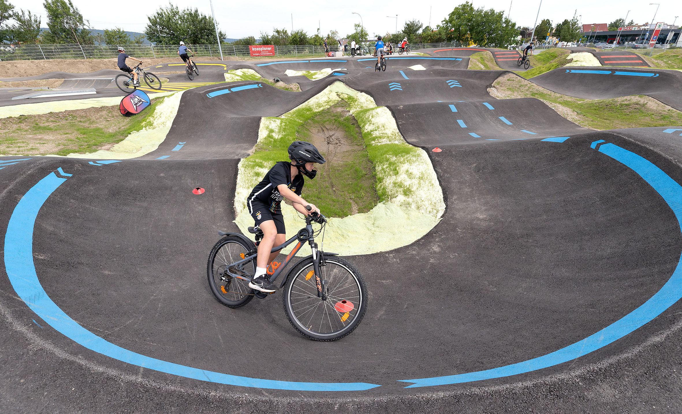 Ein Fahrradfahrer mit schwarzem Helm auf einer Pumptrack-Strecke in Wiener Neustadt.