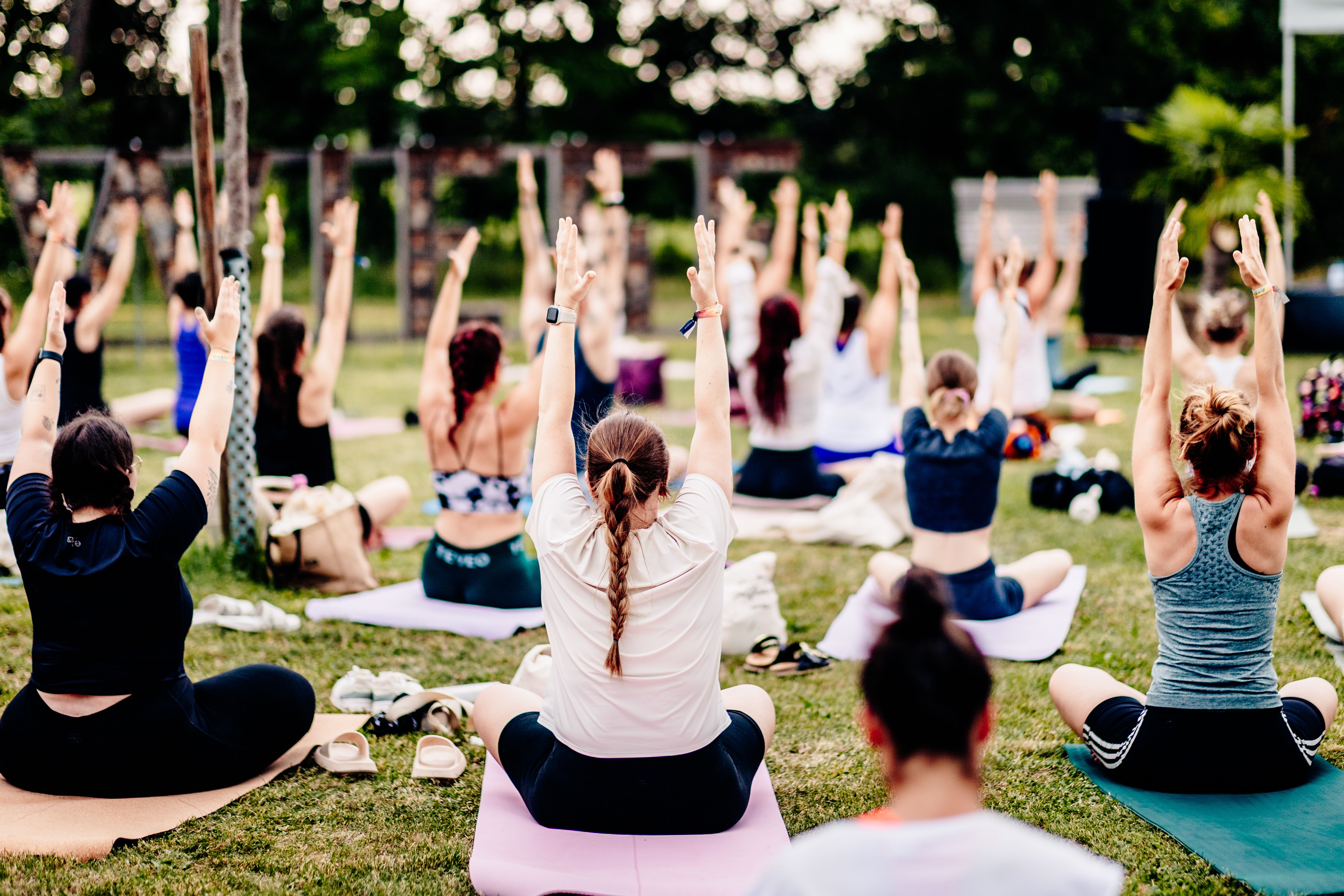 Gruppe von Menschen, die ihre Arme strecken und eine Yoga-Pose einnehmen