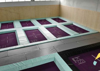 Mehrere Trampoline in einem Raum mit Holzwänden.