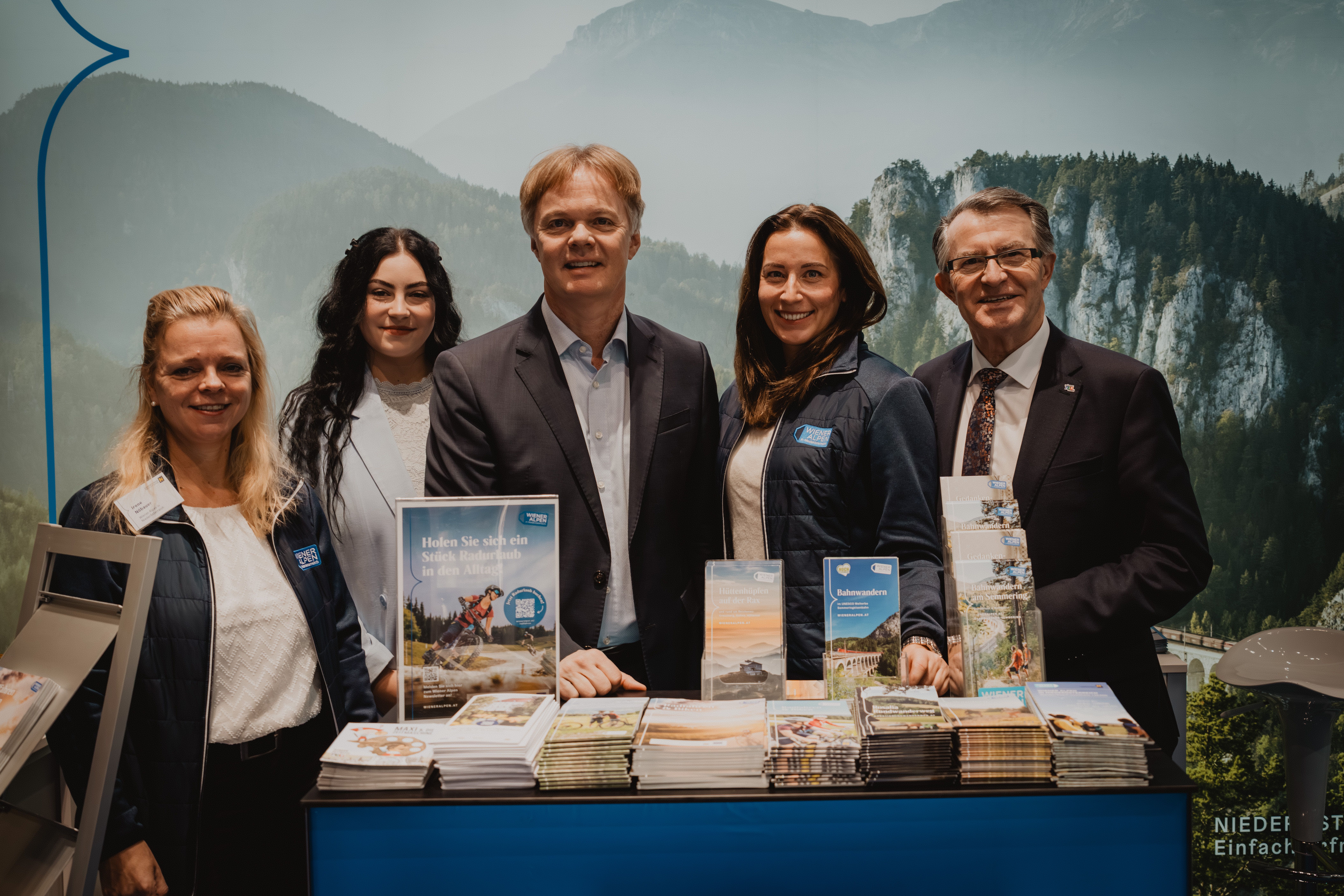 Drei Damen und zwei Herren vor dem Wiener Alpen Stand