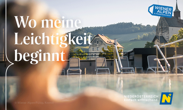Im Vordergrund sind die Umrisse einer Frau zu erkennen. Sie blickt auf ein Schwimmbecken, mit Liegen am Beckenrand und einer Kirche im Hintergrund. Über dem Foto steht der Claim "Wo meine Leichtigkeit beginnt"