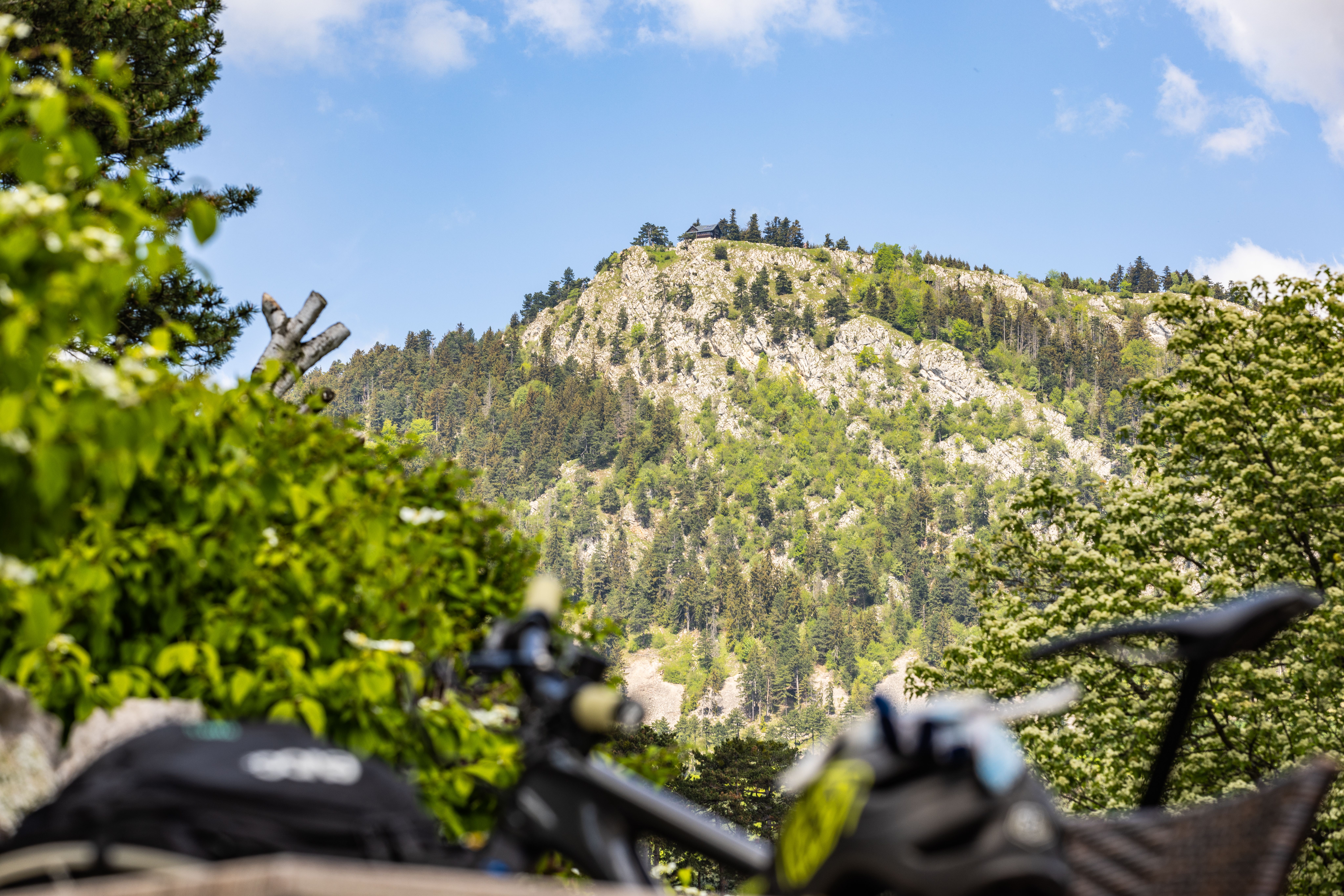 The bike is leaning against the table in the background, with the Hohen Wand landscape in the distance