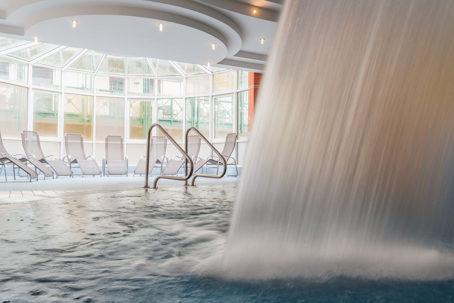 Ein entspannender Rückzugsort erwartet Sie in dieser lichtdurchfluteten Wellness-Oase. Das sanfte Plätschern des Wassers und die einladenden Liegen schaffen eine harmonische Atmosphäre, perfekt für eine Auszeit in den Wiener Alpen.