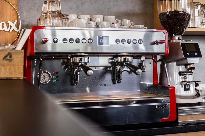 Professionelle Espressomaschine mit Tassen und Kaffeemühle.