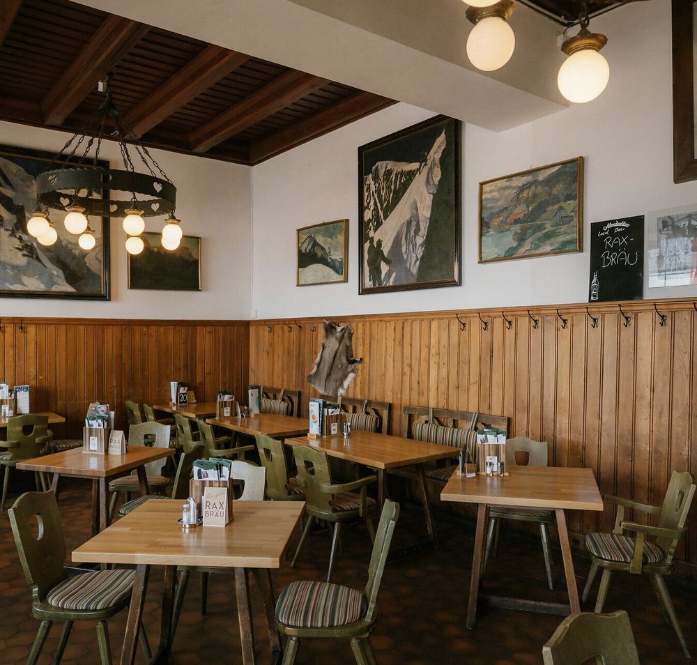 Dining room with a chandelier and Alpine paintings at the Raxalm Mountain Inn