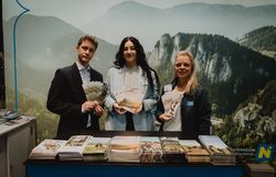 Ein Mann und zwei Damen vor dem Wiener Alpen Stand