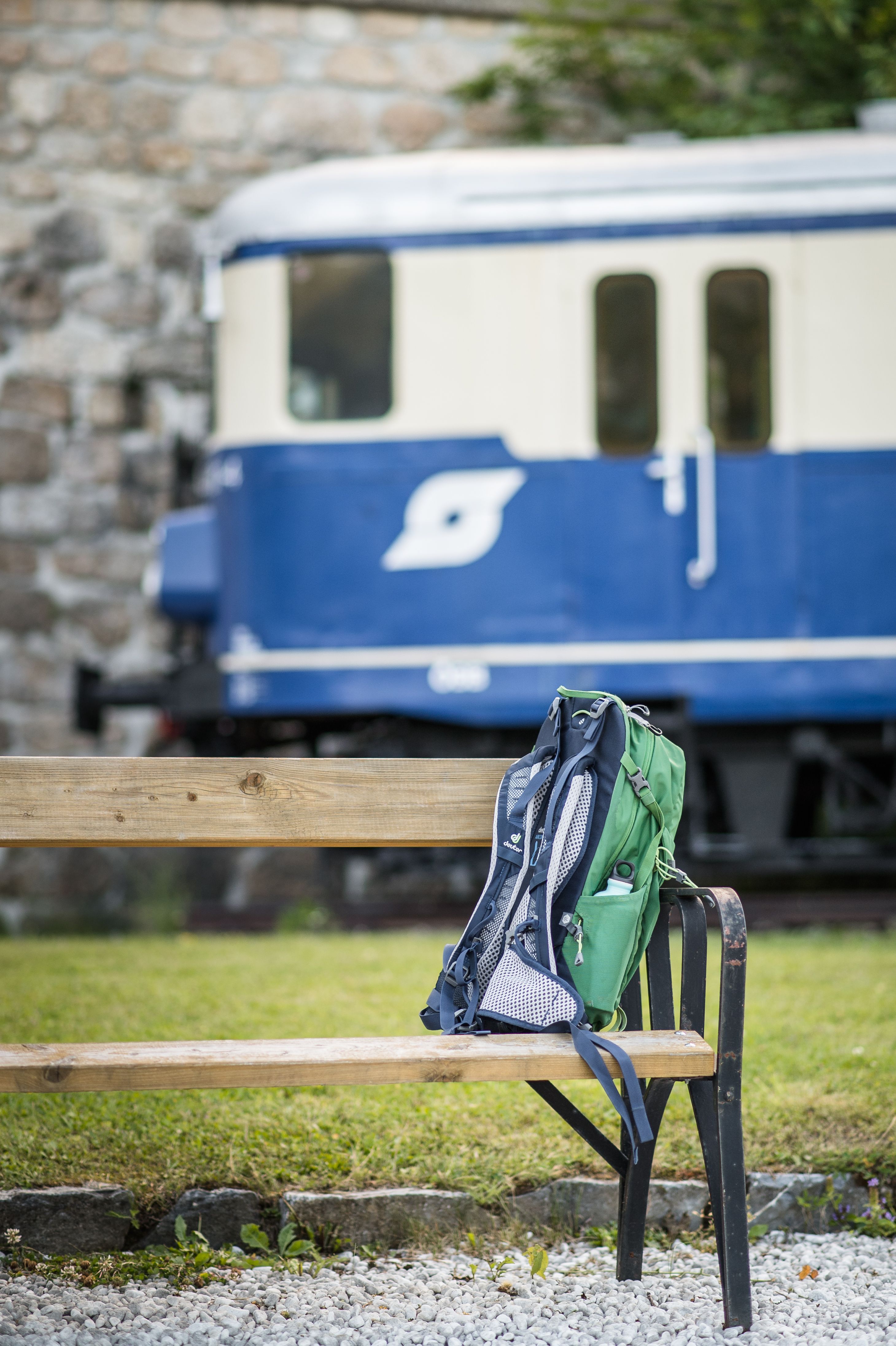 Ein Wanderer blickt auf einen Zug, der gerade über ein Viadukt fährt.