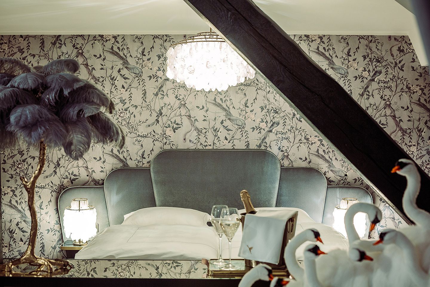 Elegantes Schlafzimmer mit luxuriösem Bett, Kronleuchter und dekorativen Schwänen.