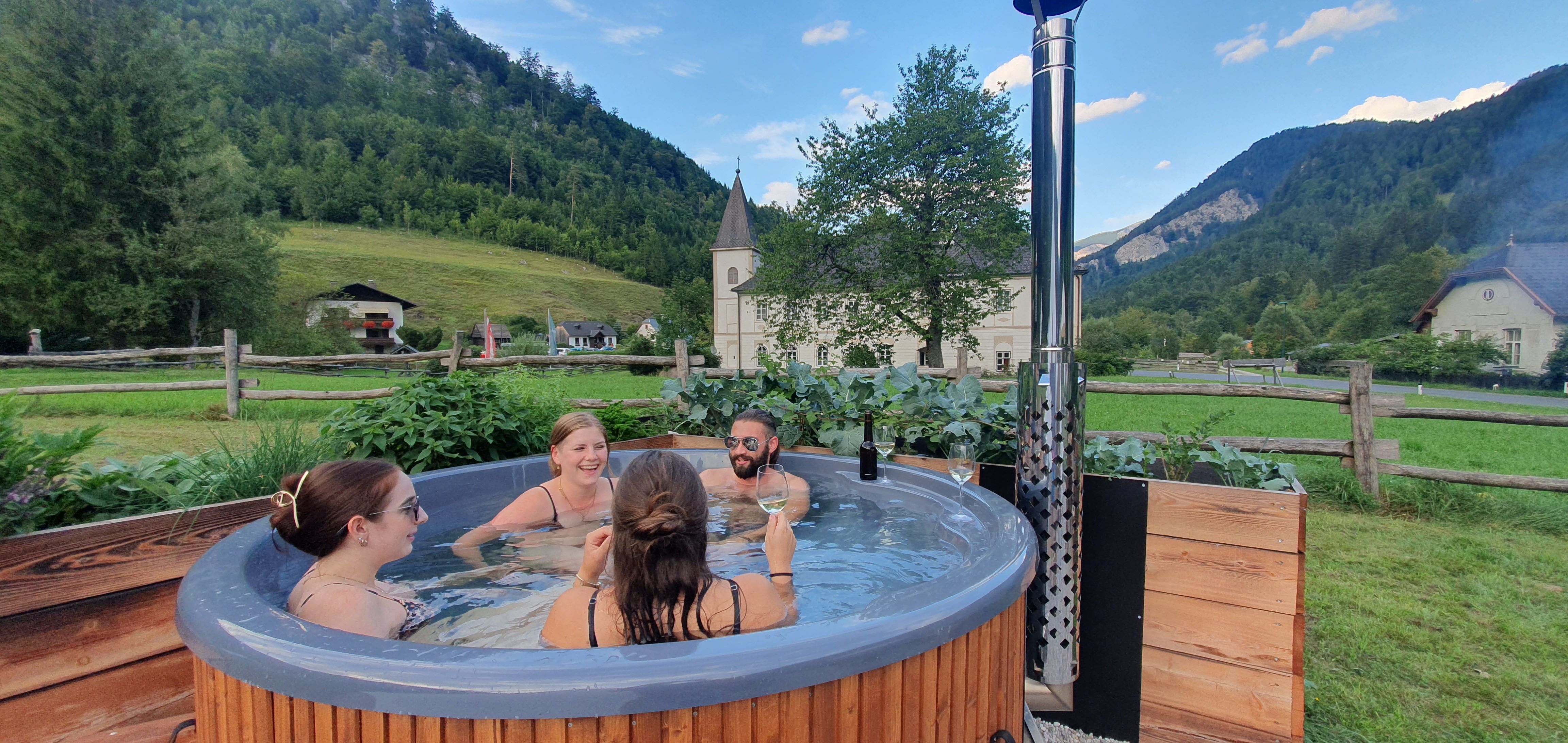 Gruppe von Menschen in einem Hot Tub in ländlicher Umgebung.