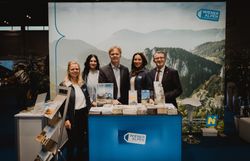 Drei Damen und zwei Herren vor dem Wiener Alpen Stand 