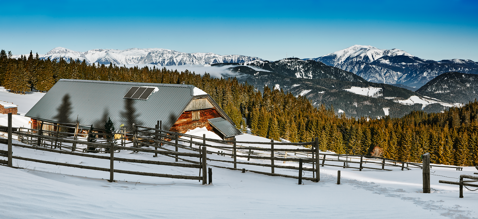 Inmitten einer winterlichen Landschaft erstrahlt eine charmante Hütte, umgeben von schneebedeckten Wäldern und majestätischen Bergen. Die klare, kalte Luft und der strahlend blaue Himmel schaffen eine friedliche Atmosphäre, die zum Verweilen einlädt. Hier, wo die Natur in ihrer reinsten Form erlebbar ist, wird jeder Schritt zum unvergesslichen Abenteuer.
