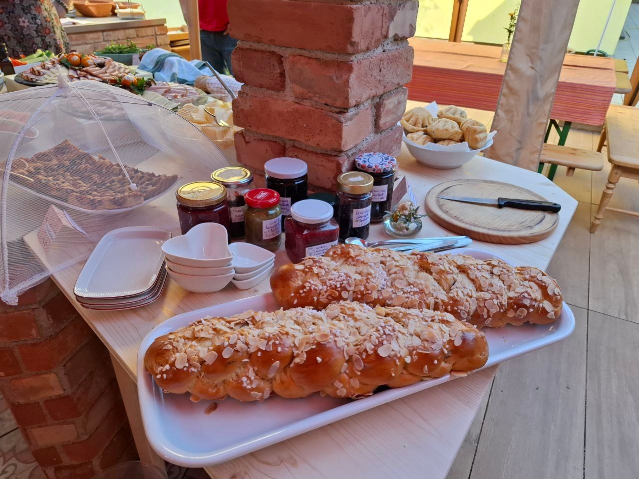 Ein Tisch mit Gebäck, Marmeladengläsern und Geschirr in Mei Kuchl.