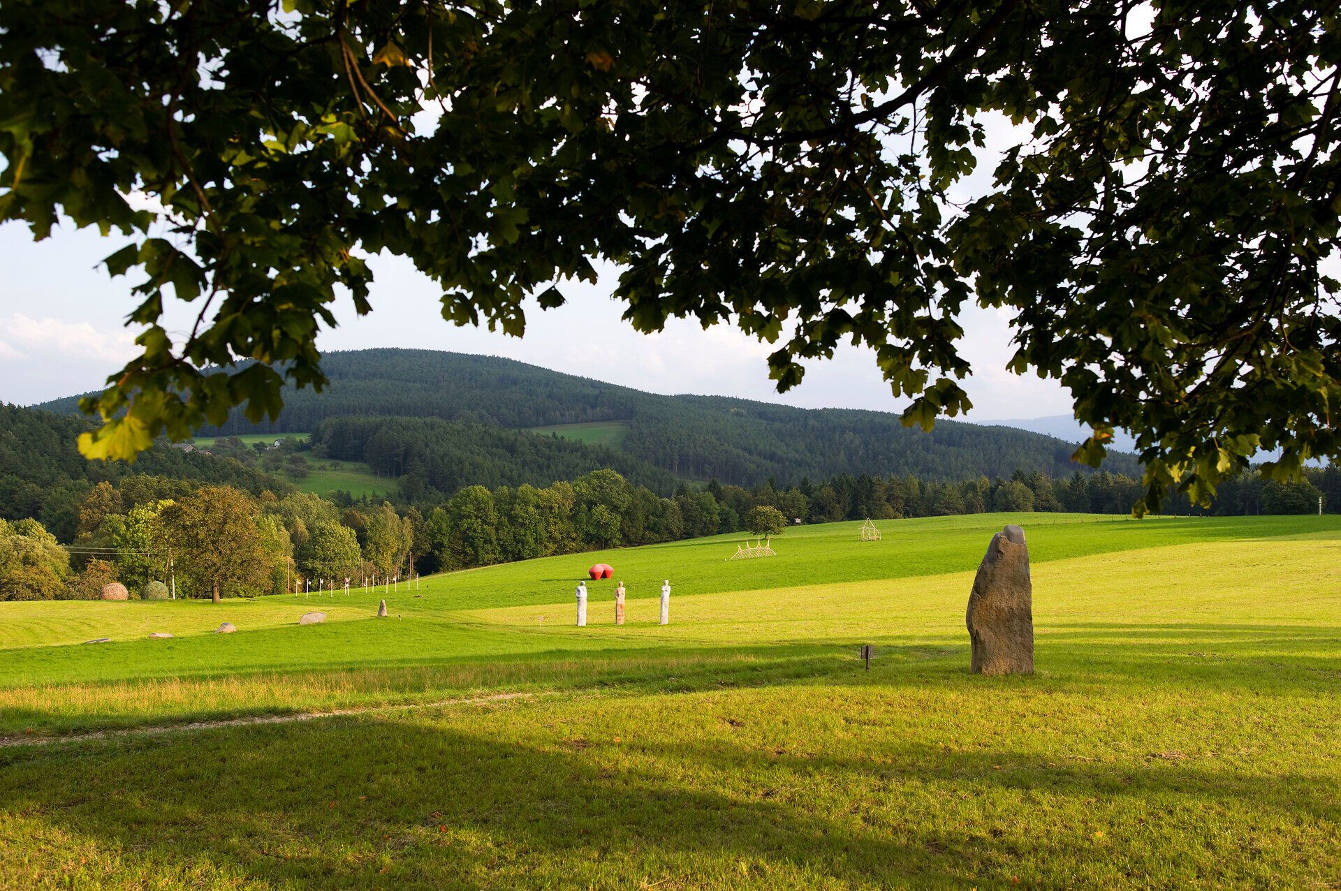 Inmitten der sanften Hügel und weitläufigen Wiesen entfaltet sich eine harmonische Verbindung von Kunst und Natur. Die skulpturalen Elemente fügen sich nahtlos in die malerische Landschaft ein und laden dazu ein, die Schönheit der Umgebung zu erkunden. Hier, wo die frische Luft und das sanfte Licht eine beruhigende Atmosphäre schaffen, wird jeder Besuch zu einem unvergesslichen Erlebnis.