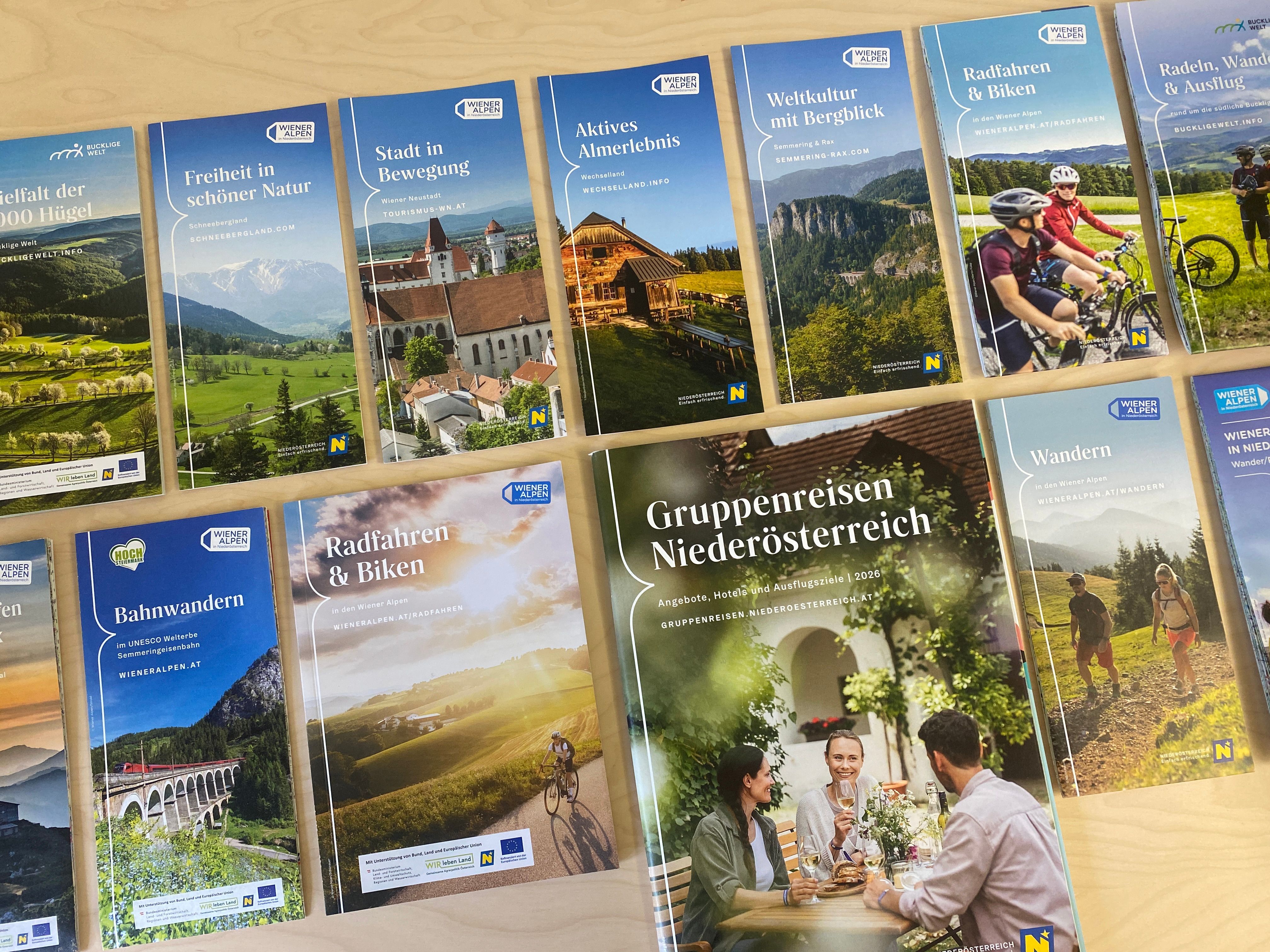 Diverse Prospekte zu verschiedenen Themen, wie Wandern oder Radfahrenk, sind auf einem Tisch aufgelegt.