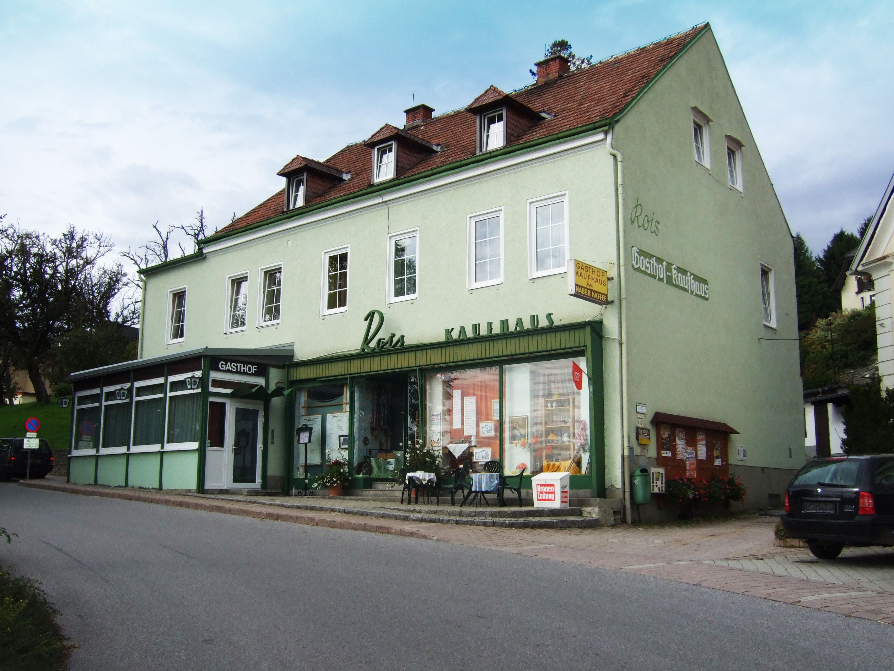 Grünes Gebäude mit der Aufschrift 'Gasthof Rois'.