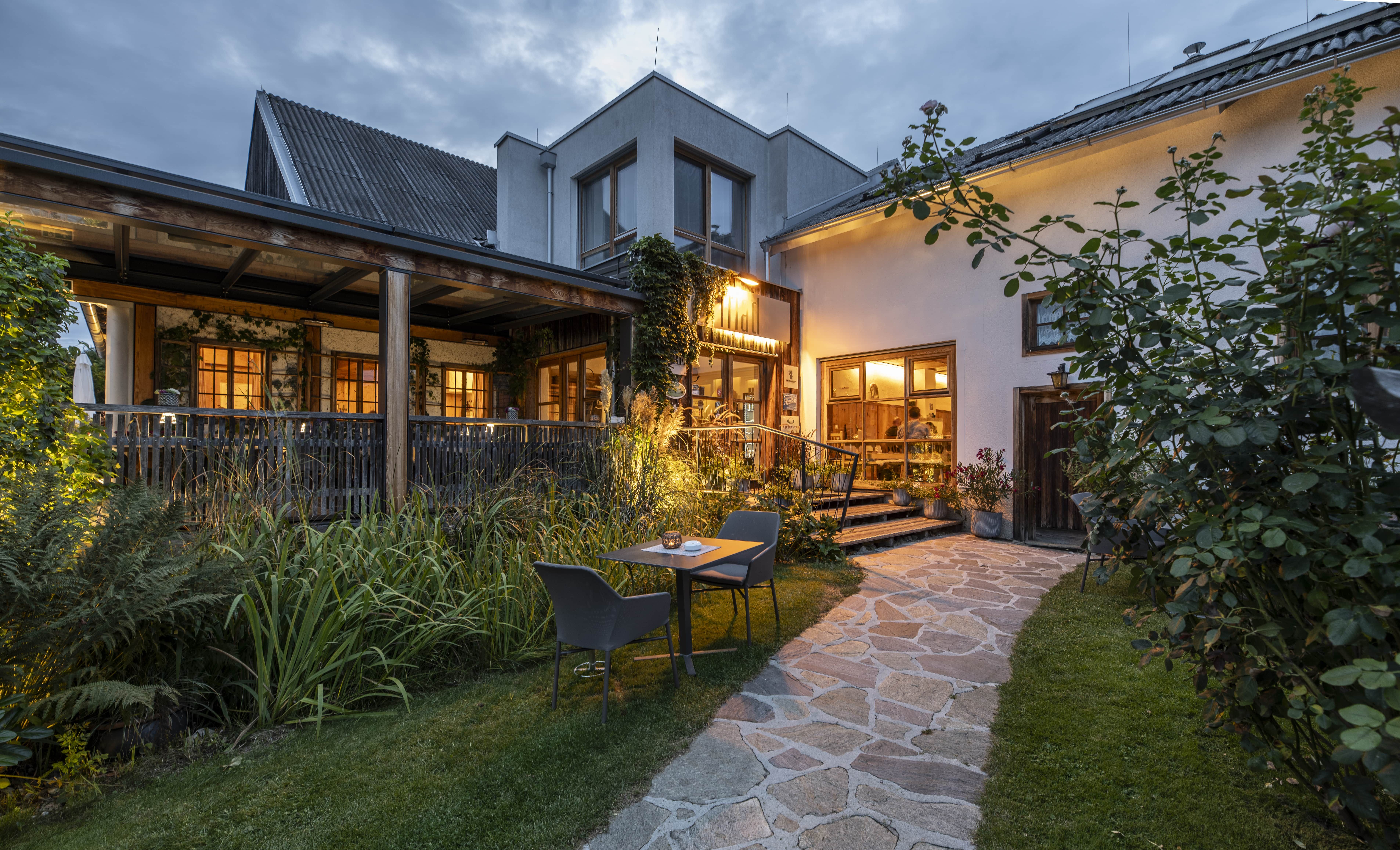 Entrance area of the Triad restaurant, illuminated in the evening and with terrace
