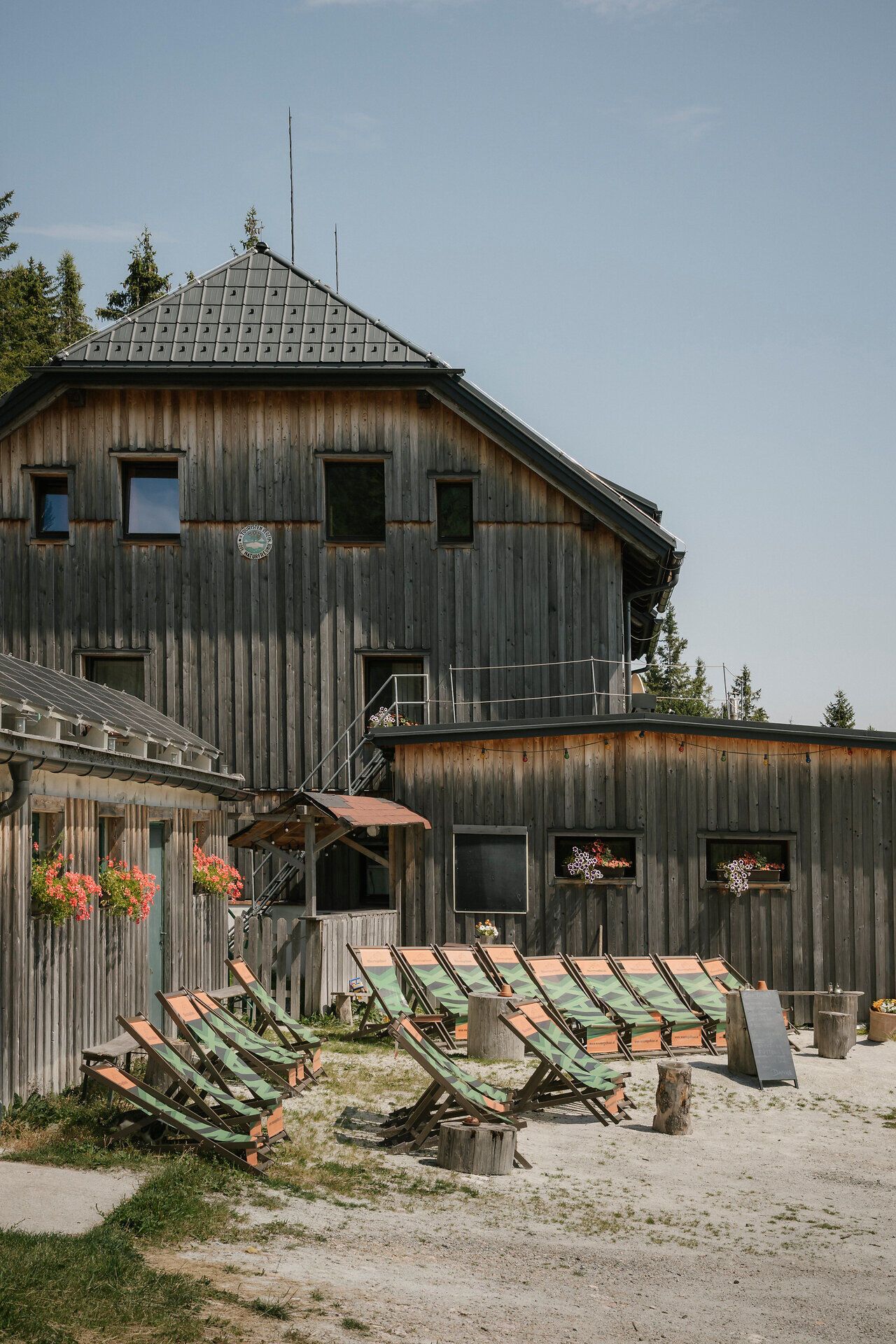 Waxriegelhaus auf der Rax mit Liegestühlen vor dem traditionellen Holzgebäude