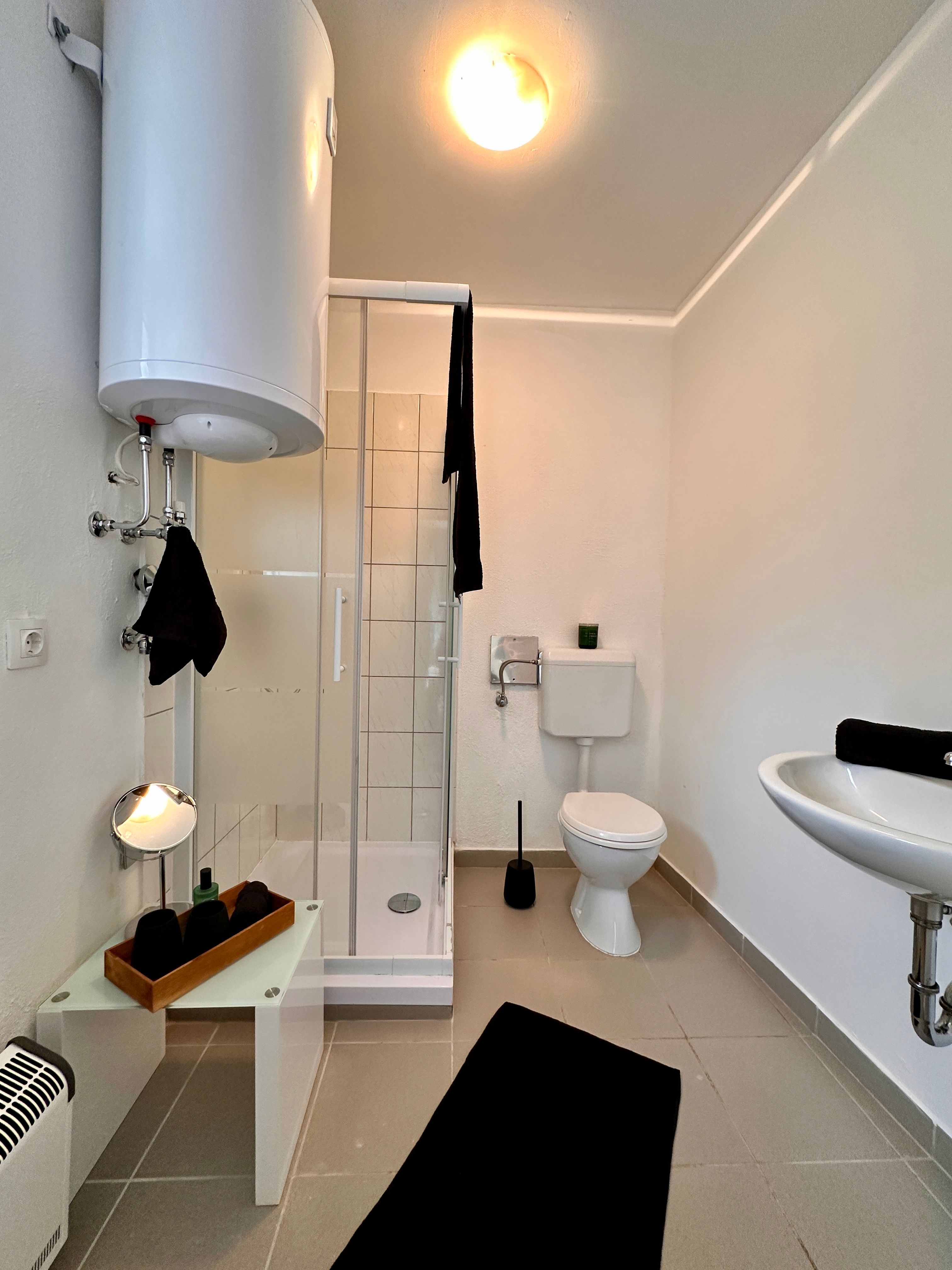 Modernes Badezimmer mit Dusche, Toilette und Waschbecken.