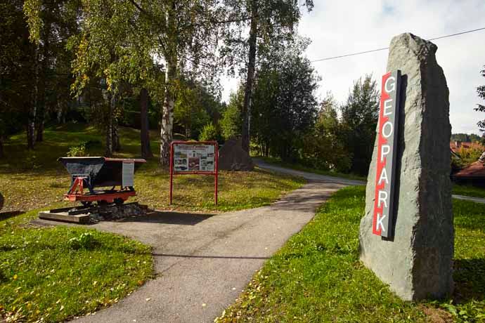 Eingang zum Geopark Aspang mit Wegweiser und Infotafel.