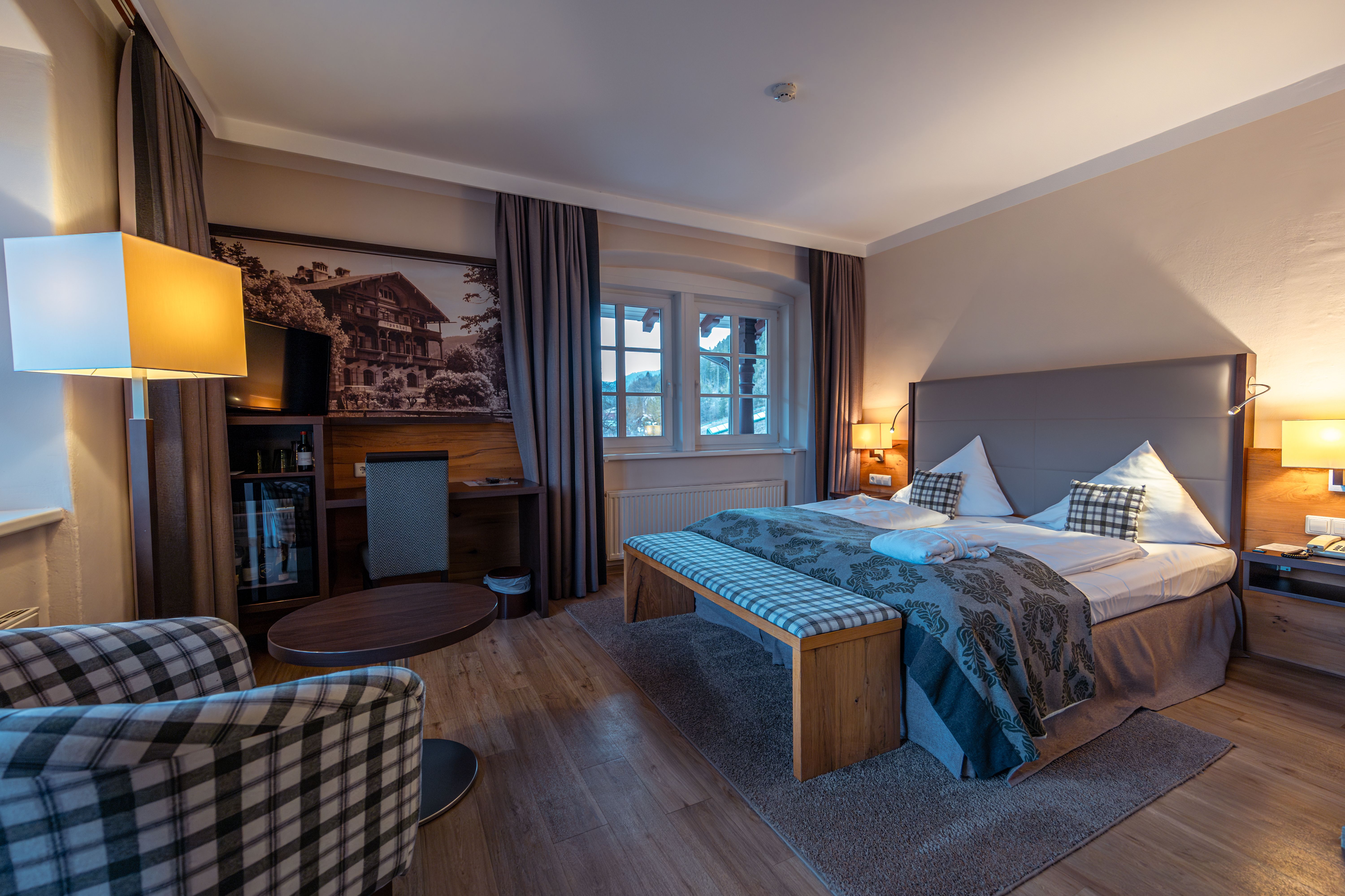 Hotelzimmer mit Bett Sofasessel und Schreibtischecke