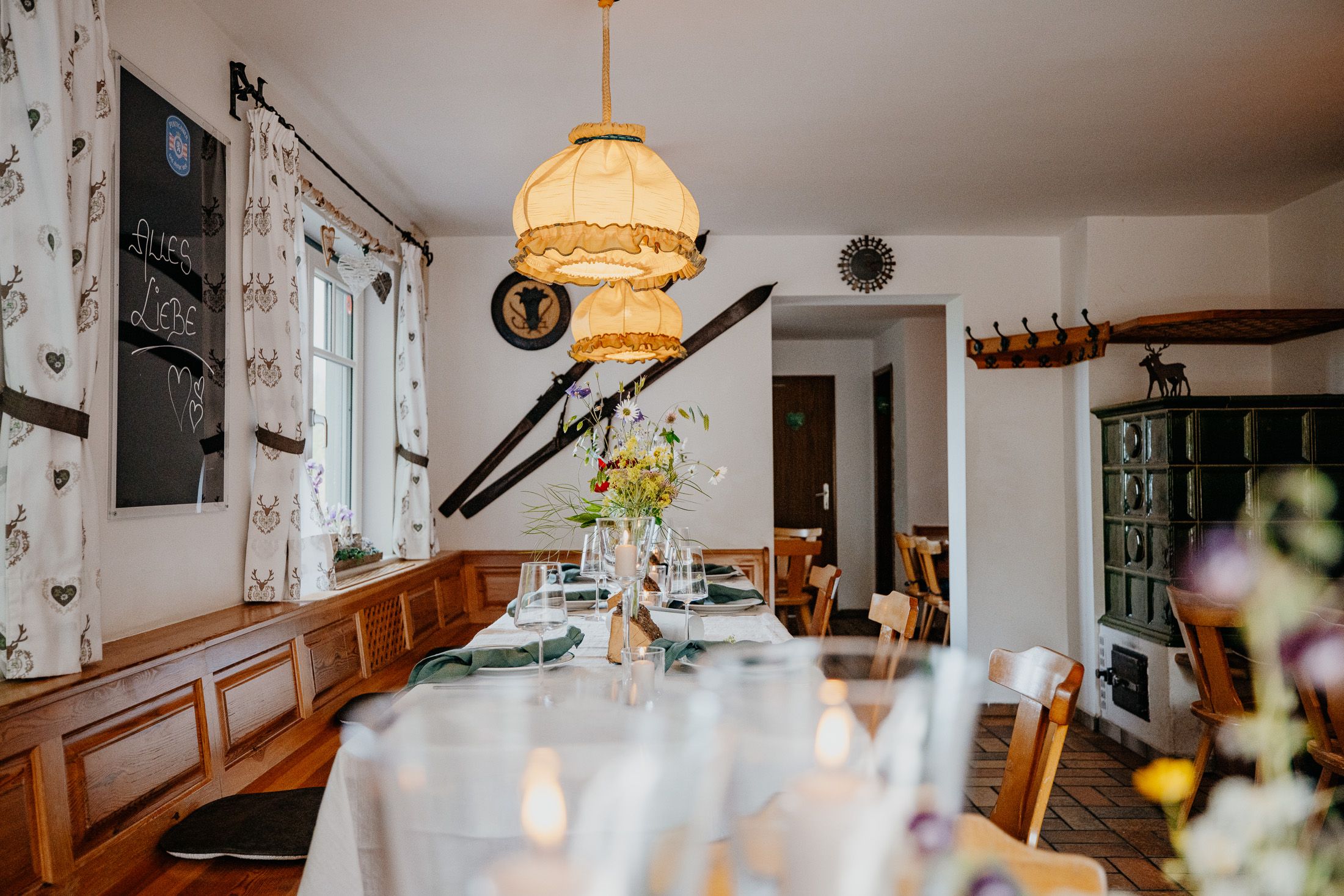 Gastzimmer der Enzianhütte mit gemütlichen Mobiliar und gedecktem Tisch.