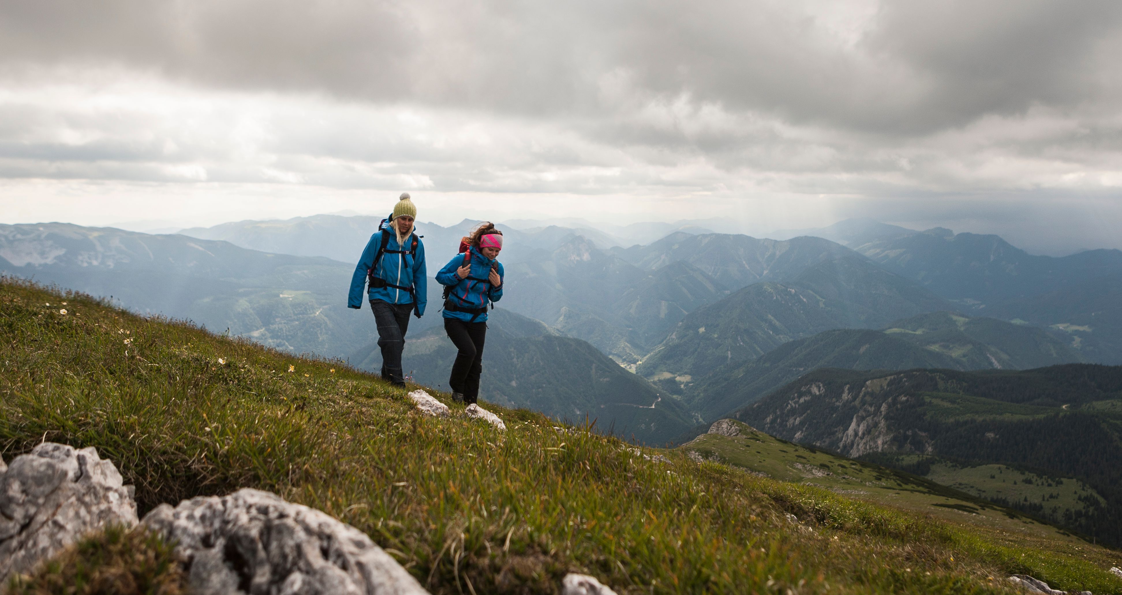 Wandere über den Bergen mit Gewitterwolken im Hintergrund