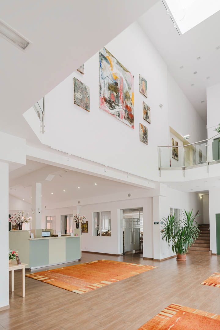 Außenansicht des Hotel Winrooms in Wiener Neustadt mit orangefarbener Fassade und Uhr.