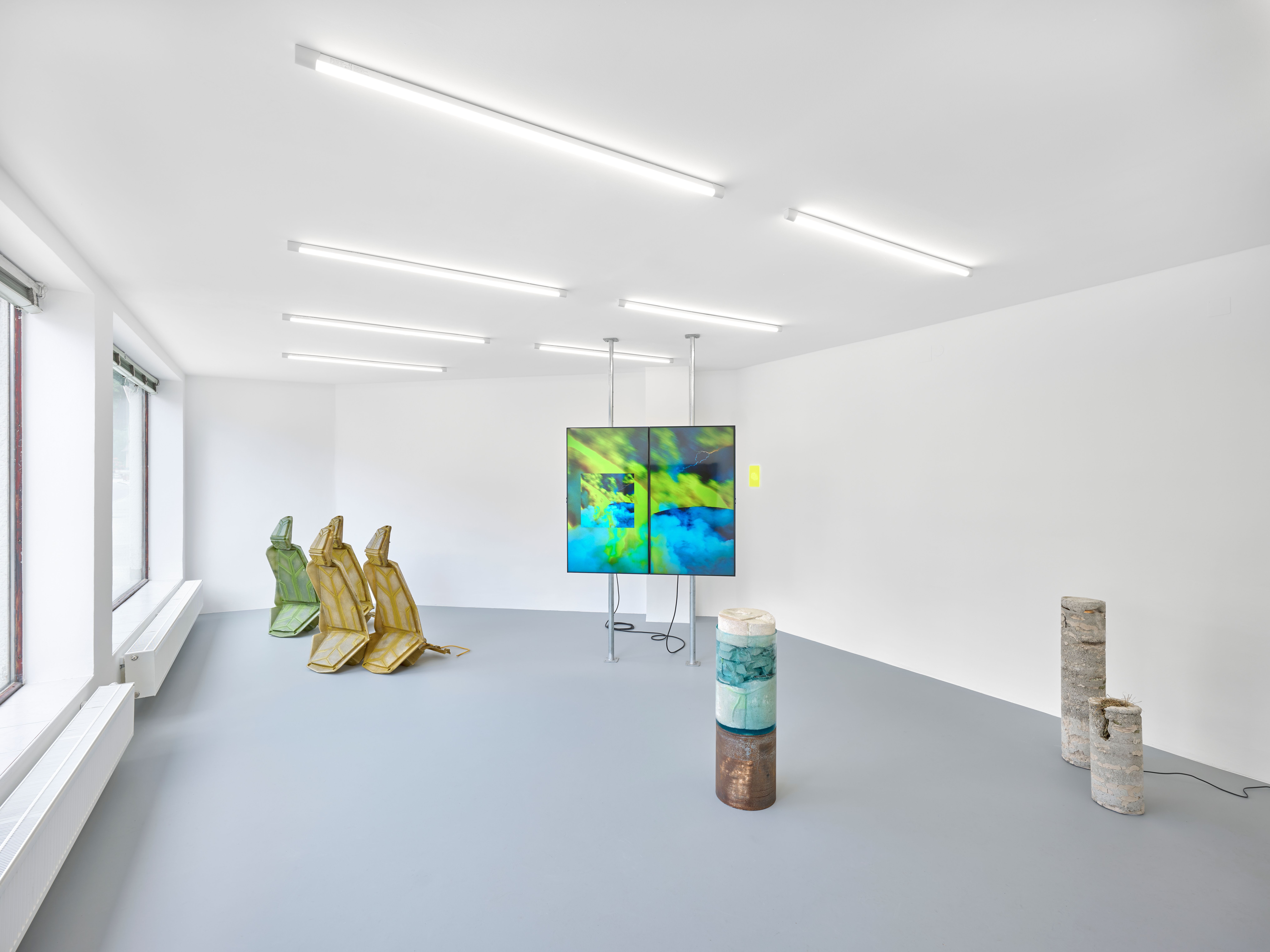 weißer Kunstraum mit Bildern und Skulpturen