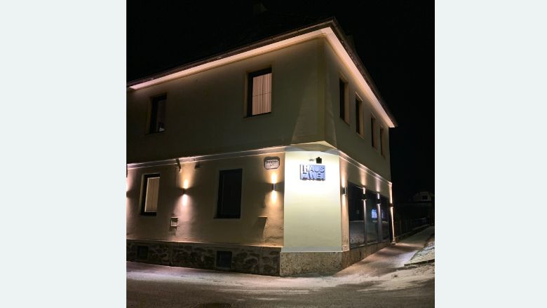Nachts beleuchtetes Gebäude mit der Aufschrift 'Haus Zwei'.
